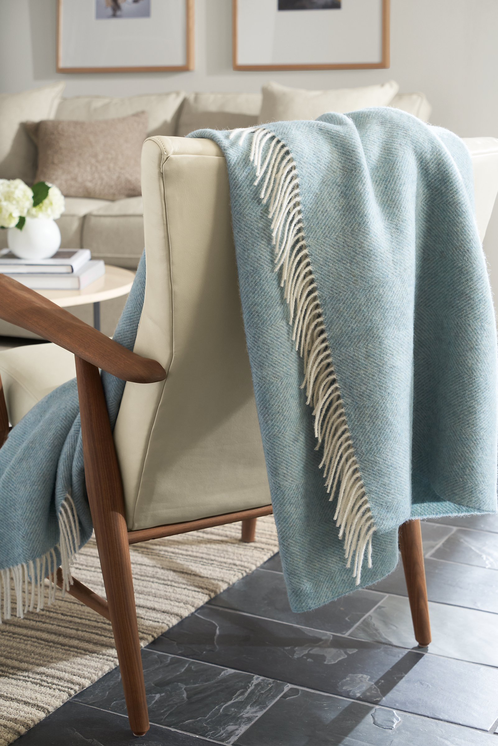 Living room setting with Claridge Throw Blanket in Sky draped over a Jonas lounge chair.