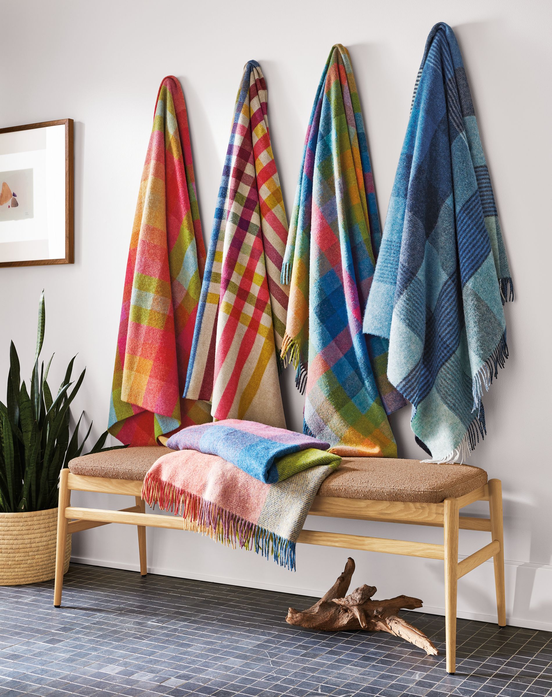 colorful throw blankets hung on hooks in entryway.
