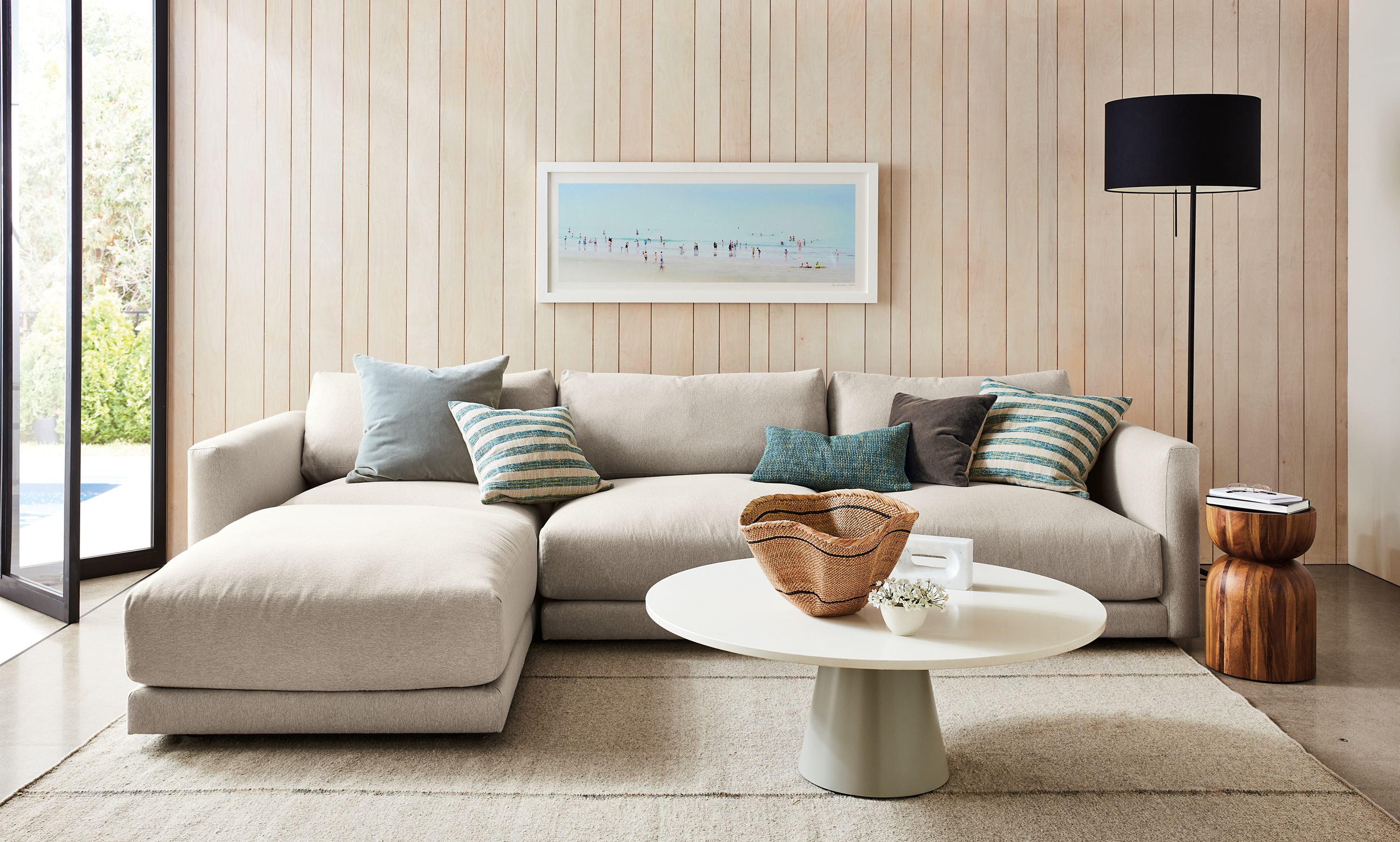 Living room with Clemens four piece modular sofa with ottoman in flint oatmeal.