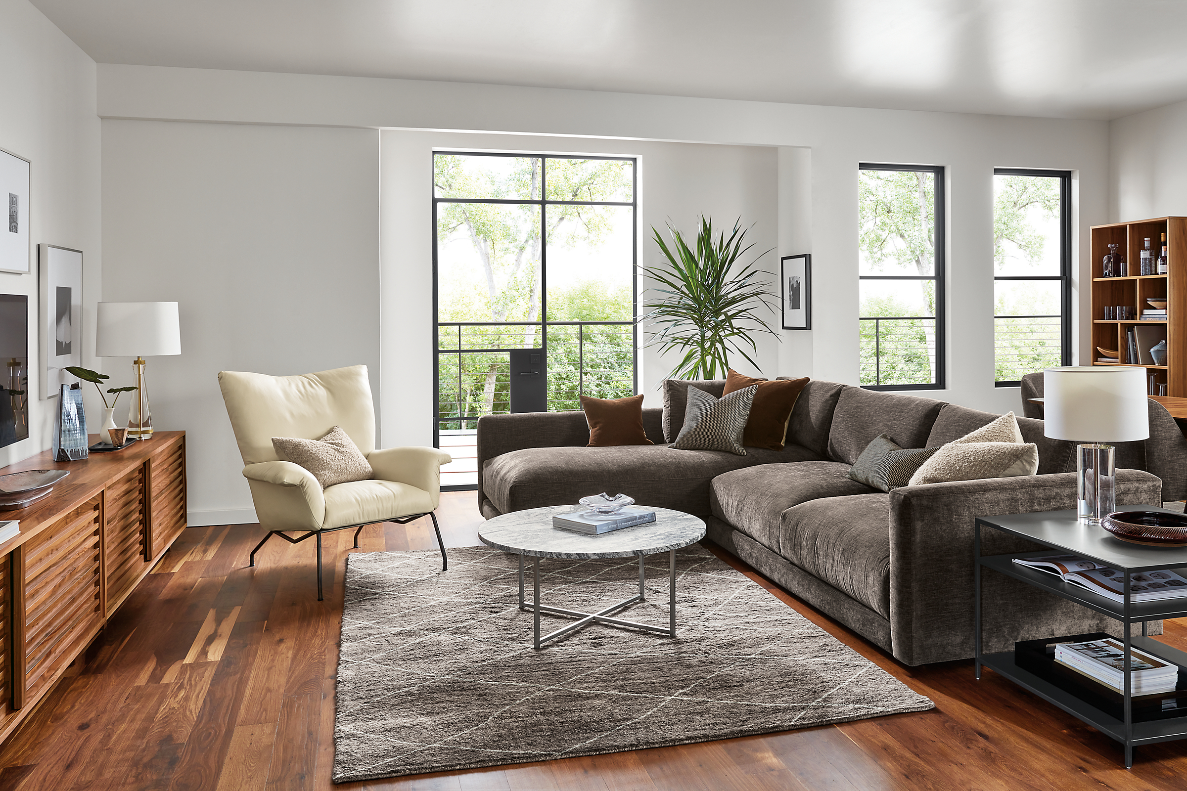 living room with clemens sectional in mori charcoal, Paris leather chair, classic coffee table.