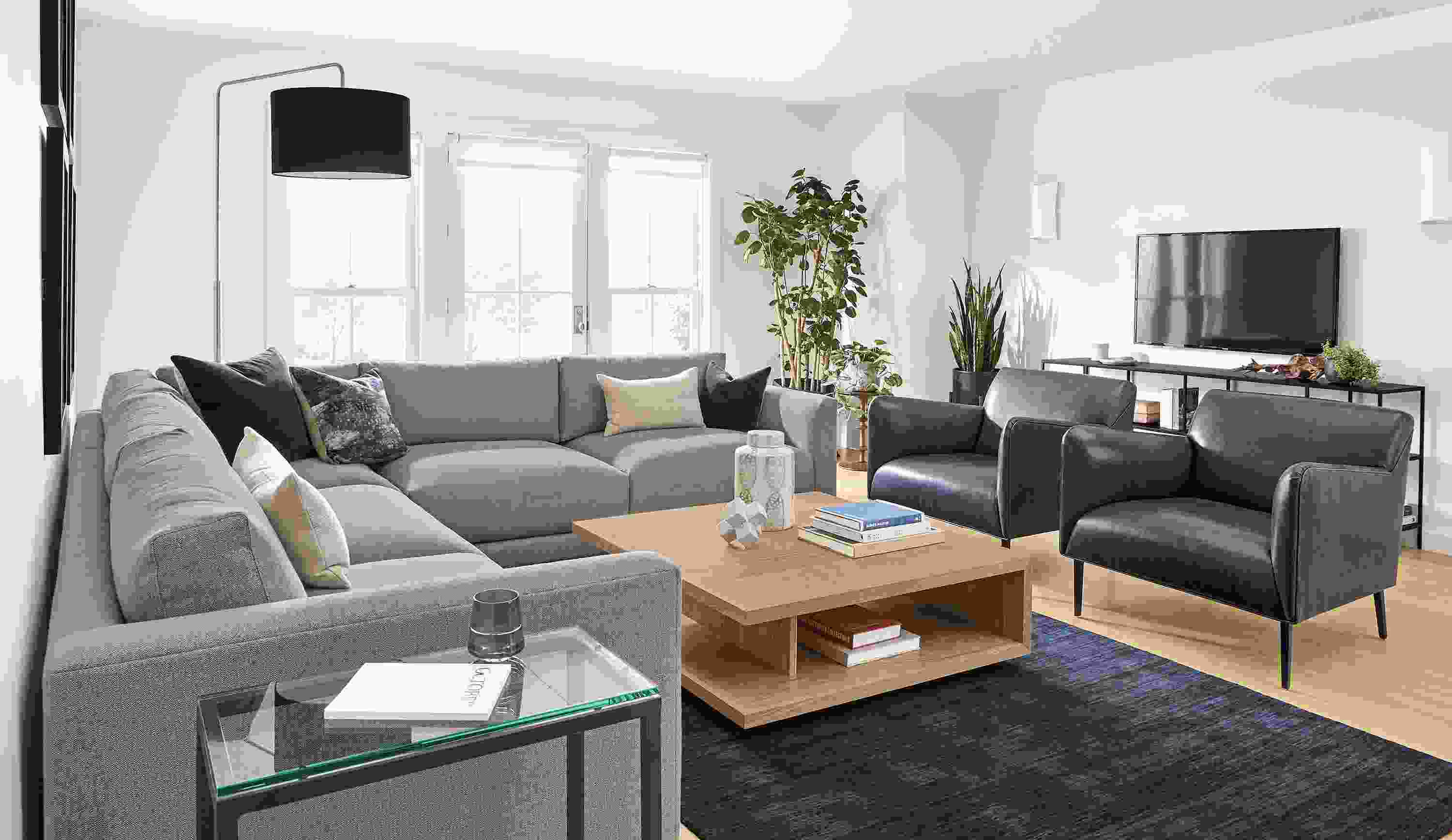 Living room with clemens 3-piece sectional in hines fabric, 2 matteo chairs in vento ink leather and nomad rug in indigo.