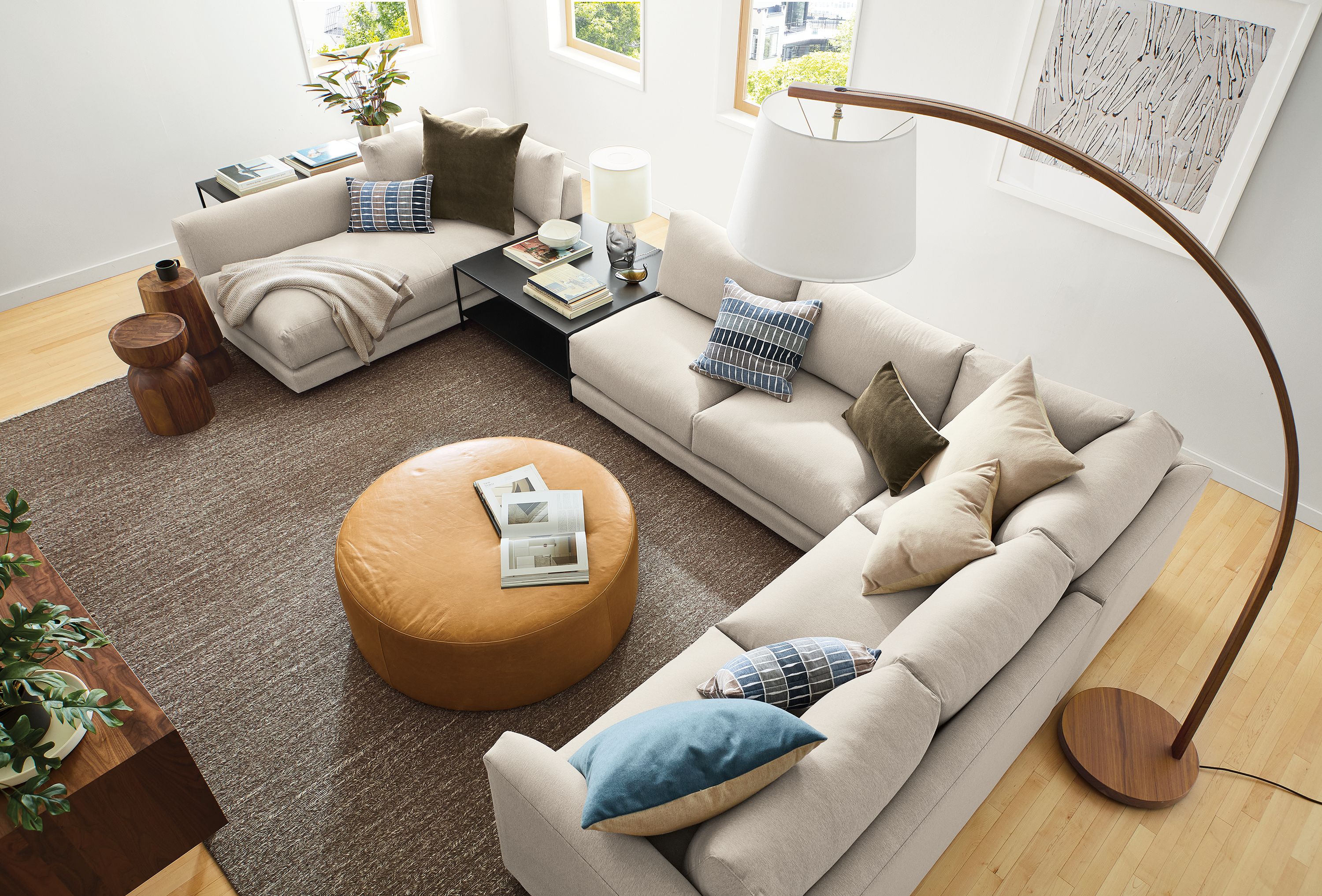Overhead view Clemens 140-wide sectional with chaise in flint oatmeal, Aero ottoman in Vento Camel, and Dia rug in foxhound.