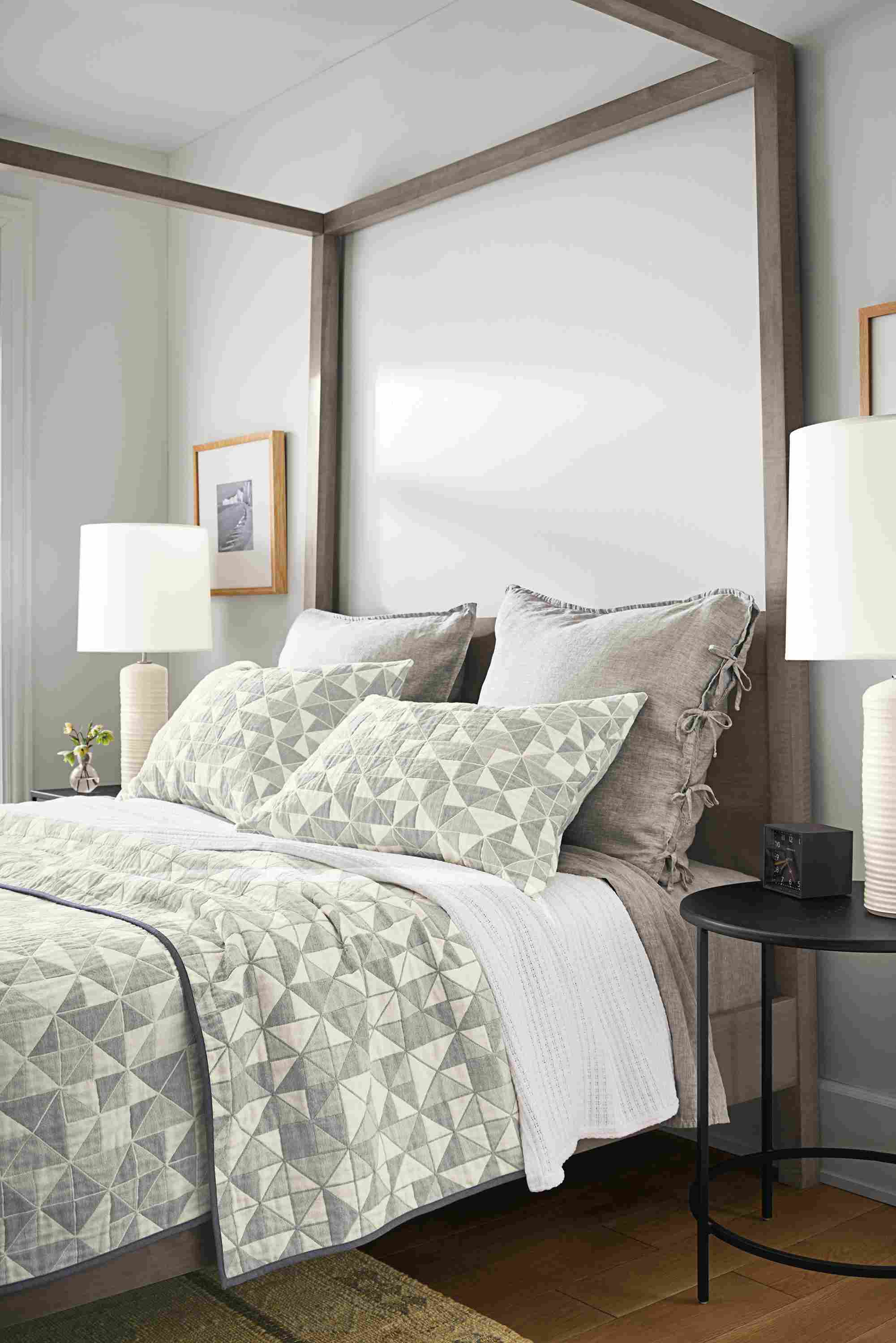 Detail of clemson coverlet and clemson shams on gray bed with linen bedding.