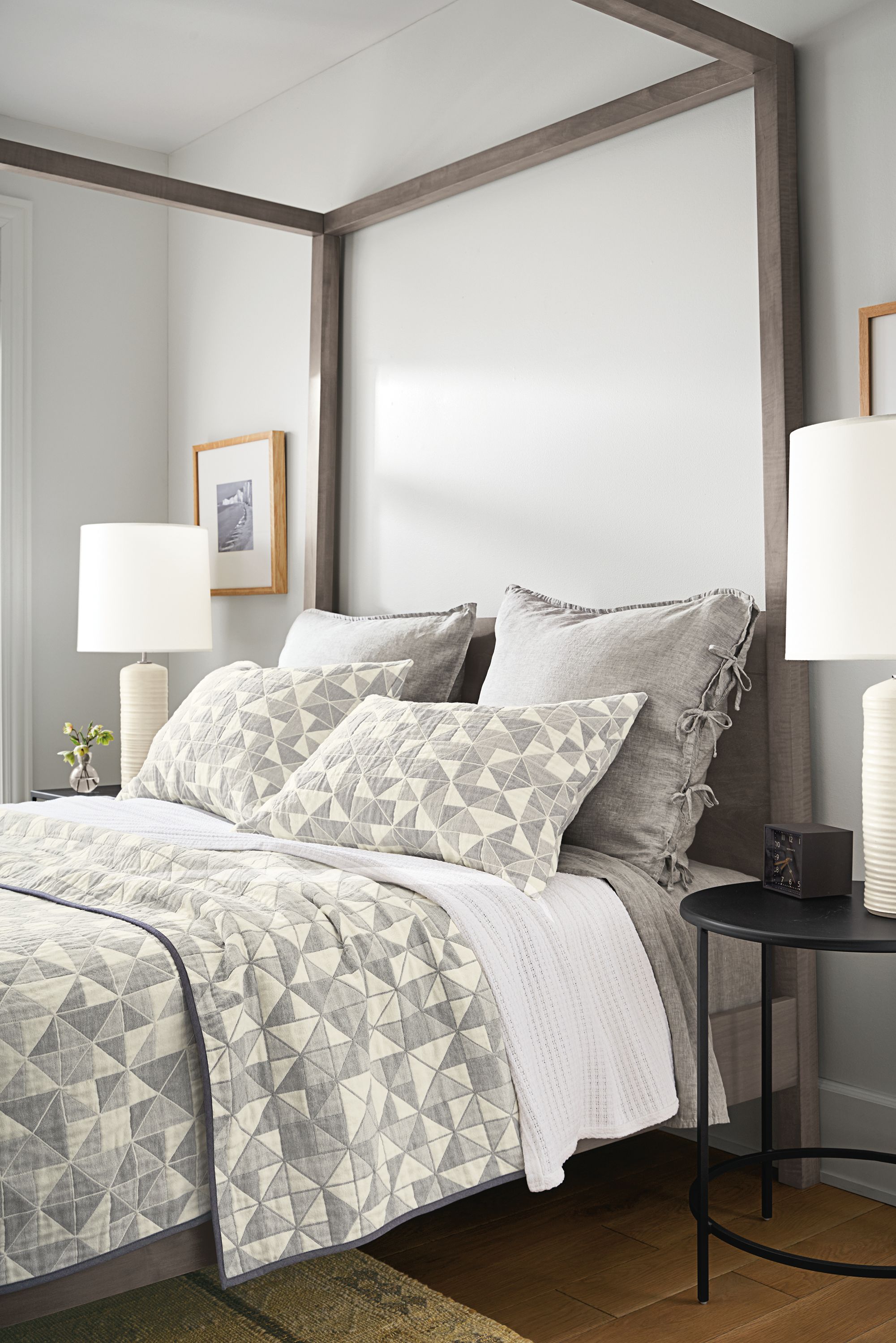 Detail of clemson coverlet and clemson shams on gray bed with linen bedding.