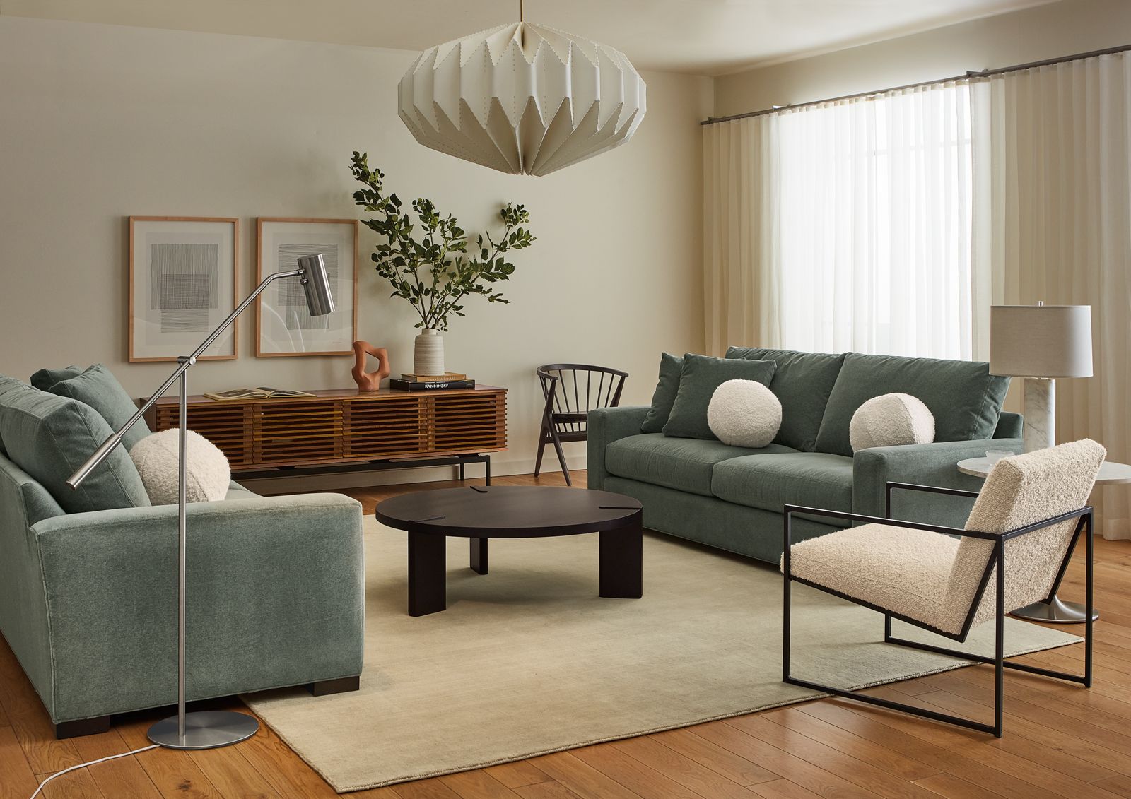 Living room setting of Coda Floor Lamp in Stainless steel, two Metro 88-inch sofas, Novato chair, Hanover coffee table in charcoal and Luco rug in silver.