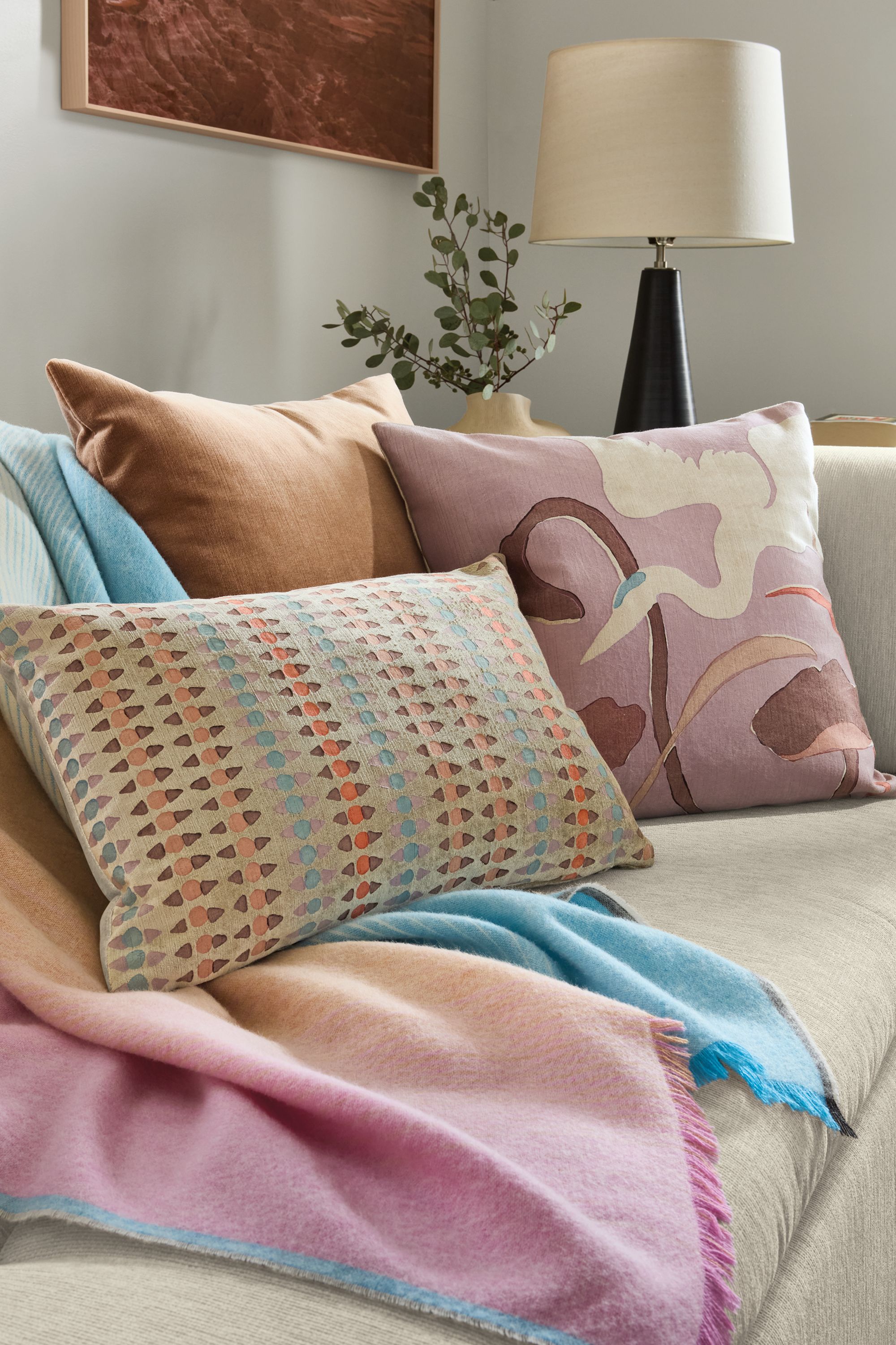 Sofa with detail of Colburn throw blanket in dawn, Stockholm pillow in spice and Heron pillow in spice.
