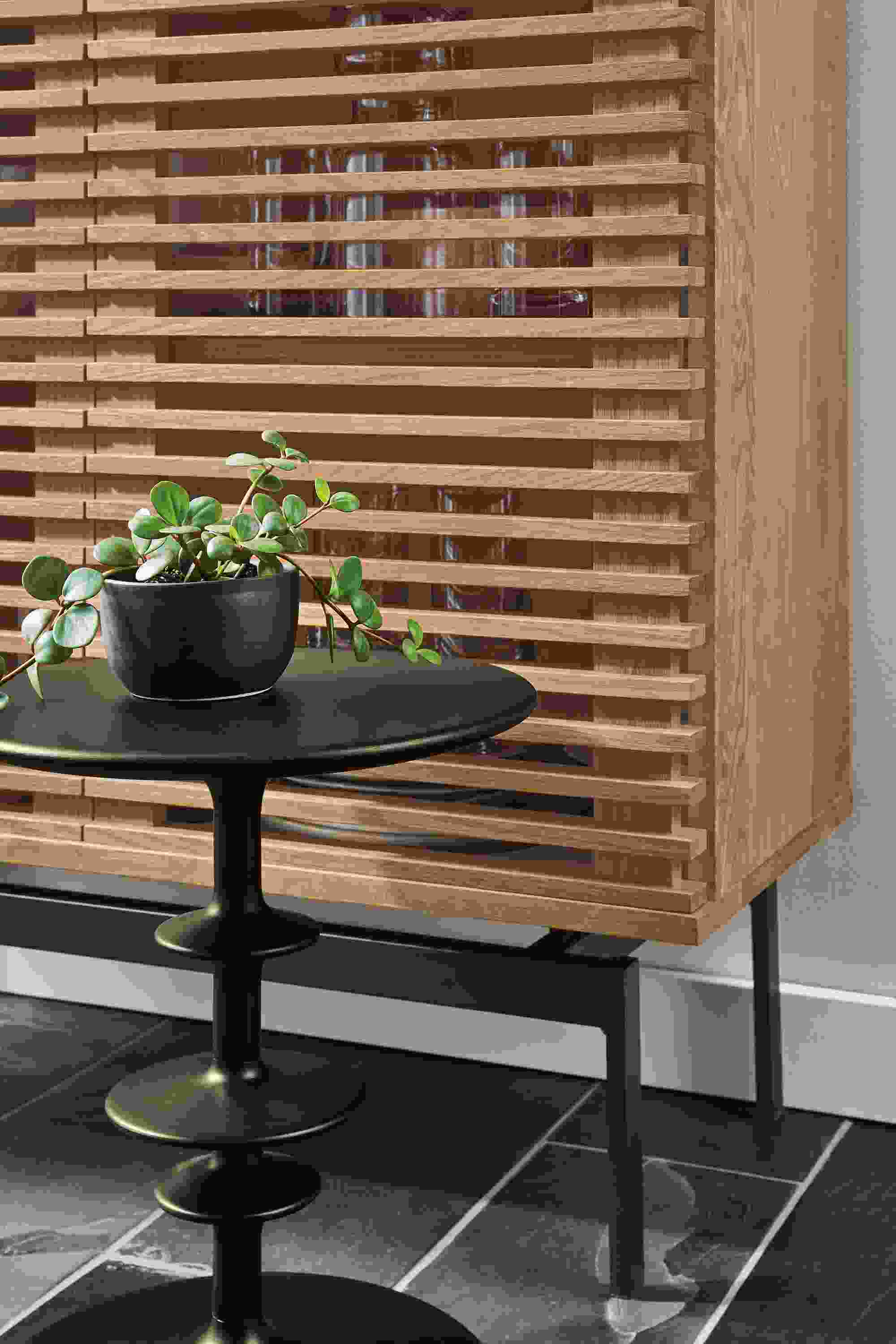 Close up of Coles 36-wide 60-high Two-Door Storage Cabinet in Rye along with Parks end table in charcoal.