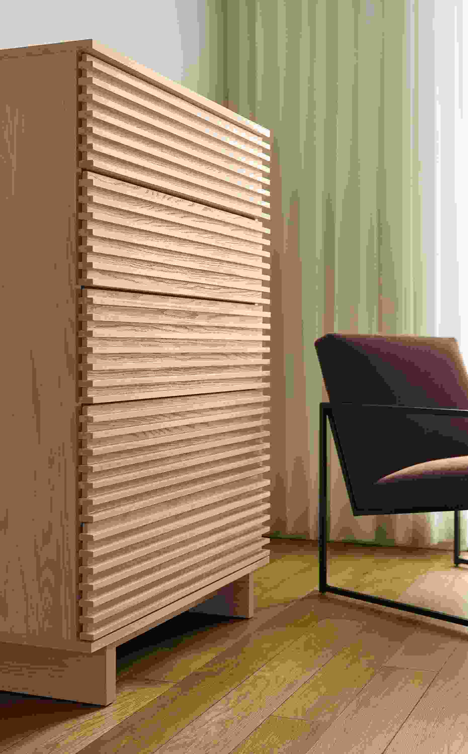 Bedroom corner with Coles 36-wide 5-drawer dresser in salt on red oak and Novato chair in Redding Espresso and Natural steel.