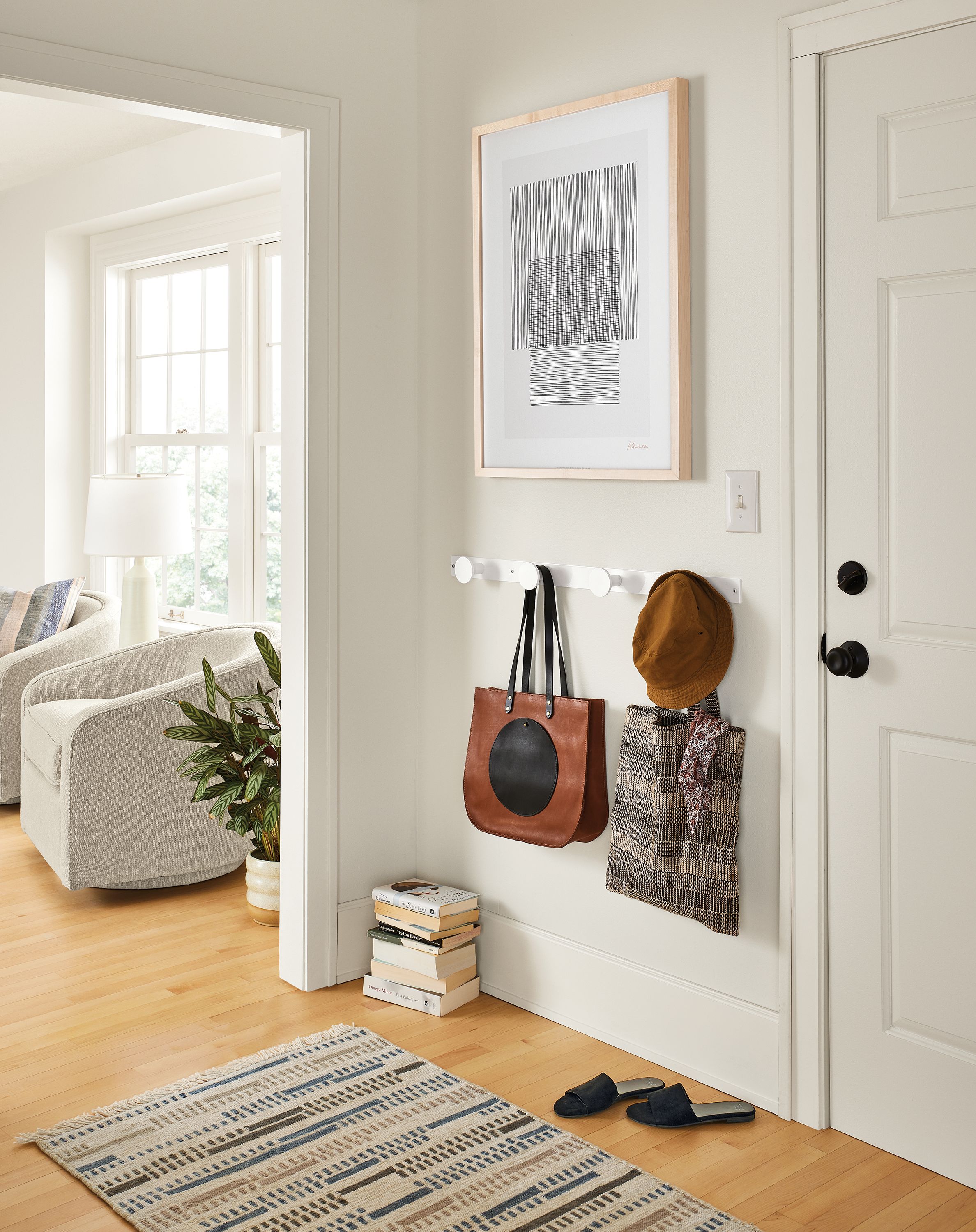 Entryway with compass wall hooks, antonio mascio wall art, morse rug.