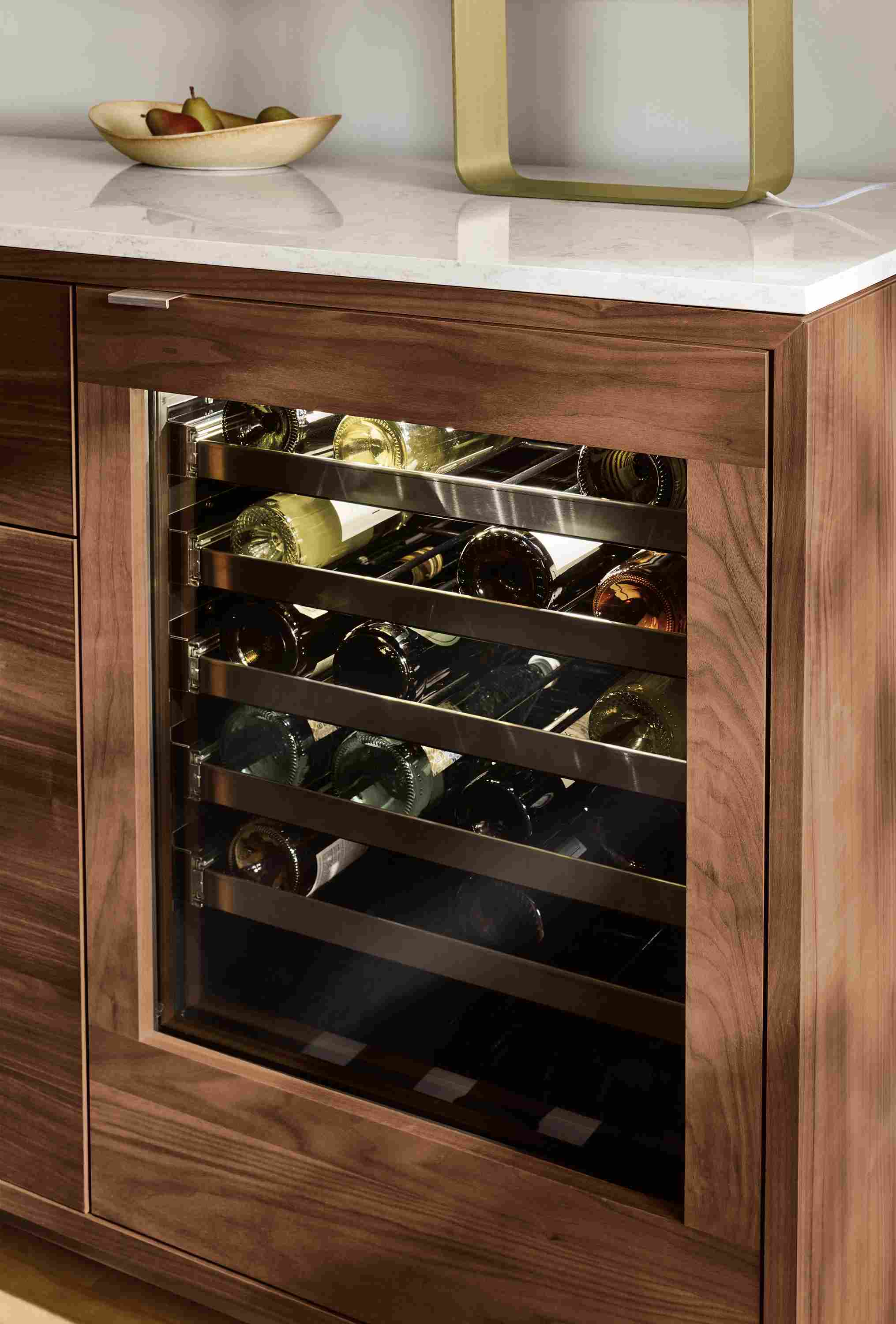 Detail of Copenhagen 72-wide fridge cabinet in walnut with stainless steel hardware and marble white quartz top.