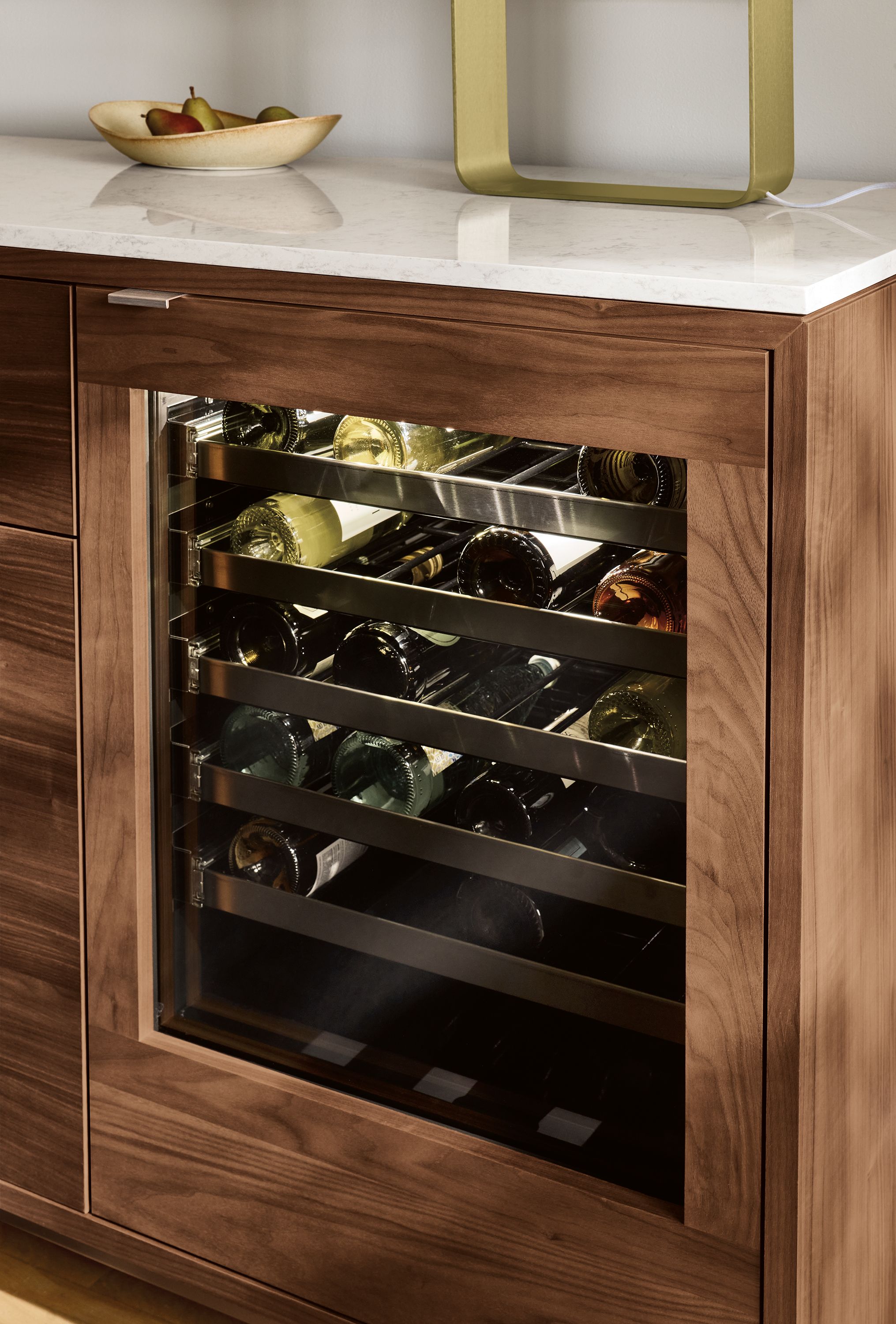 Detail of Copenhagen 72-wide fridge cabinet in walnut with stainless steel hardware and marble white quartz top.