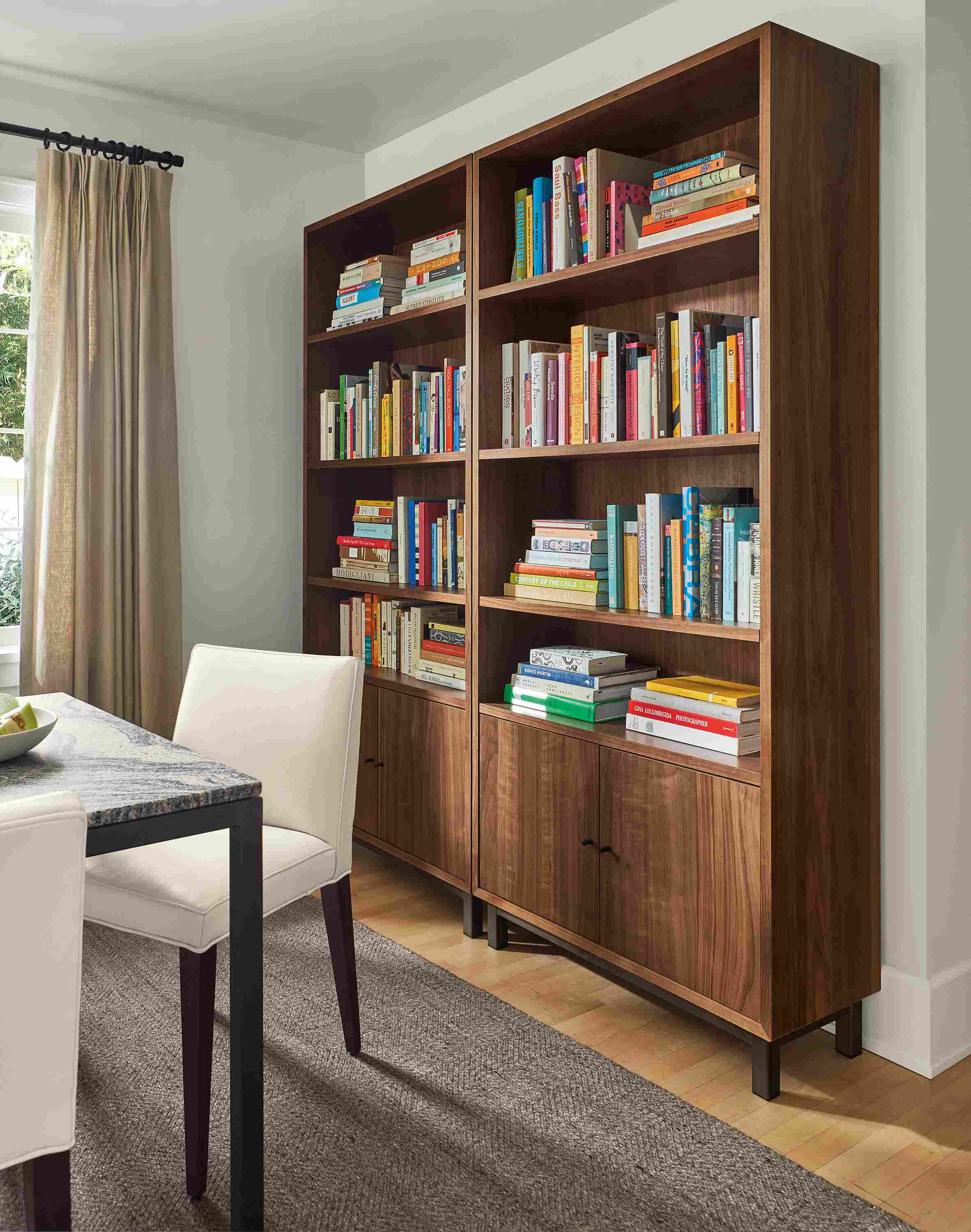 Living room with two Copenhagen 36-wide bookcases in walnut and avilia rug in foxhound.