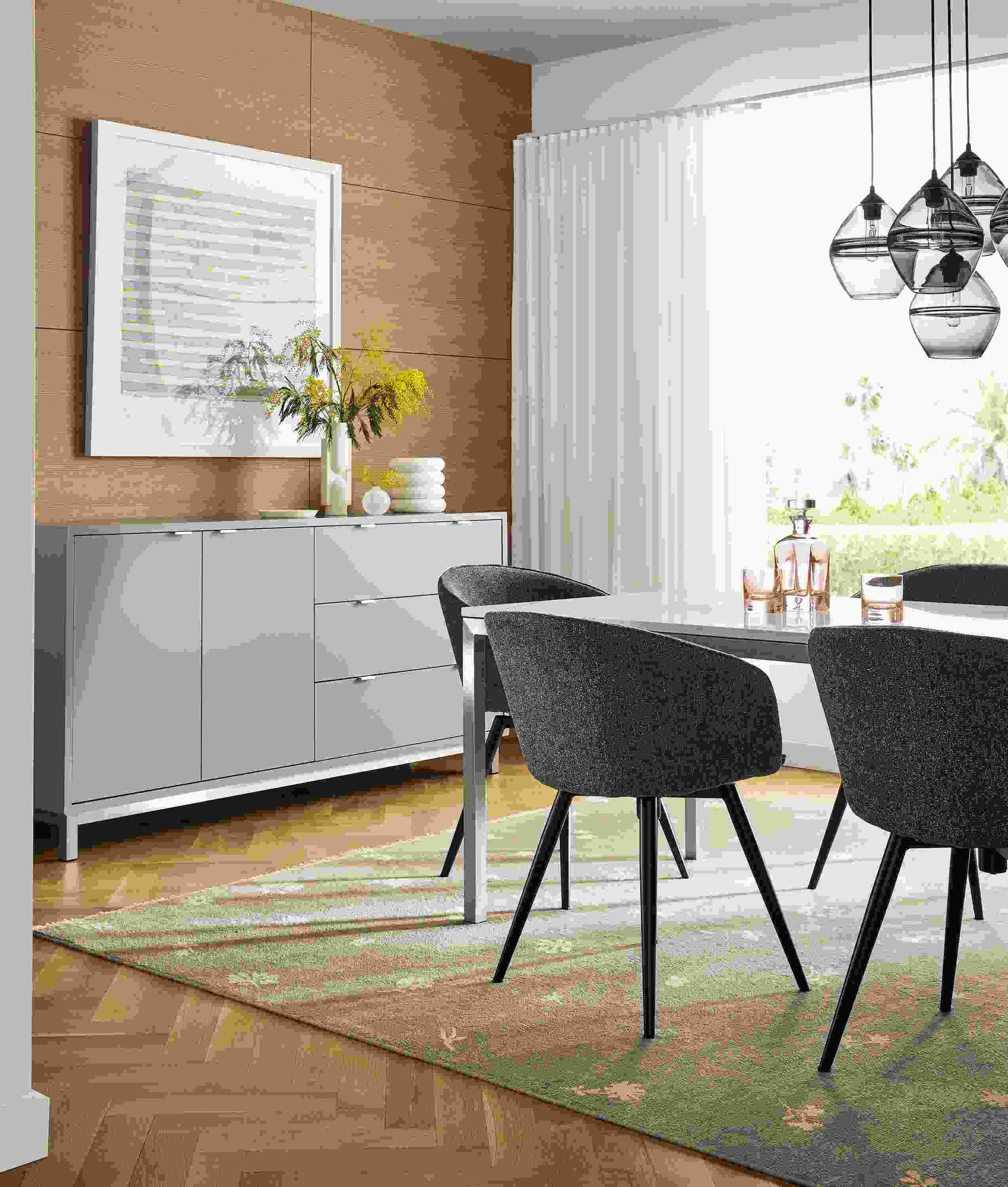 Dining area with Copenhagen 72-wide cabinet in taupe with Marbled white quartz top, Parsons table and Sylvan swivel chairs and Tansy rug.