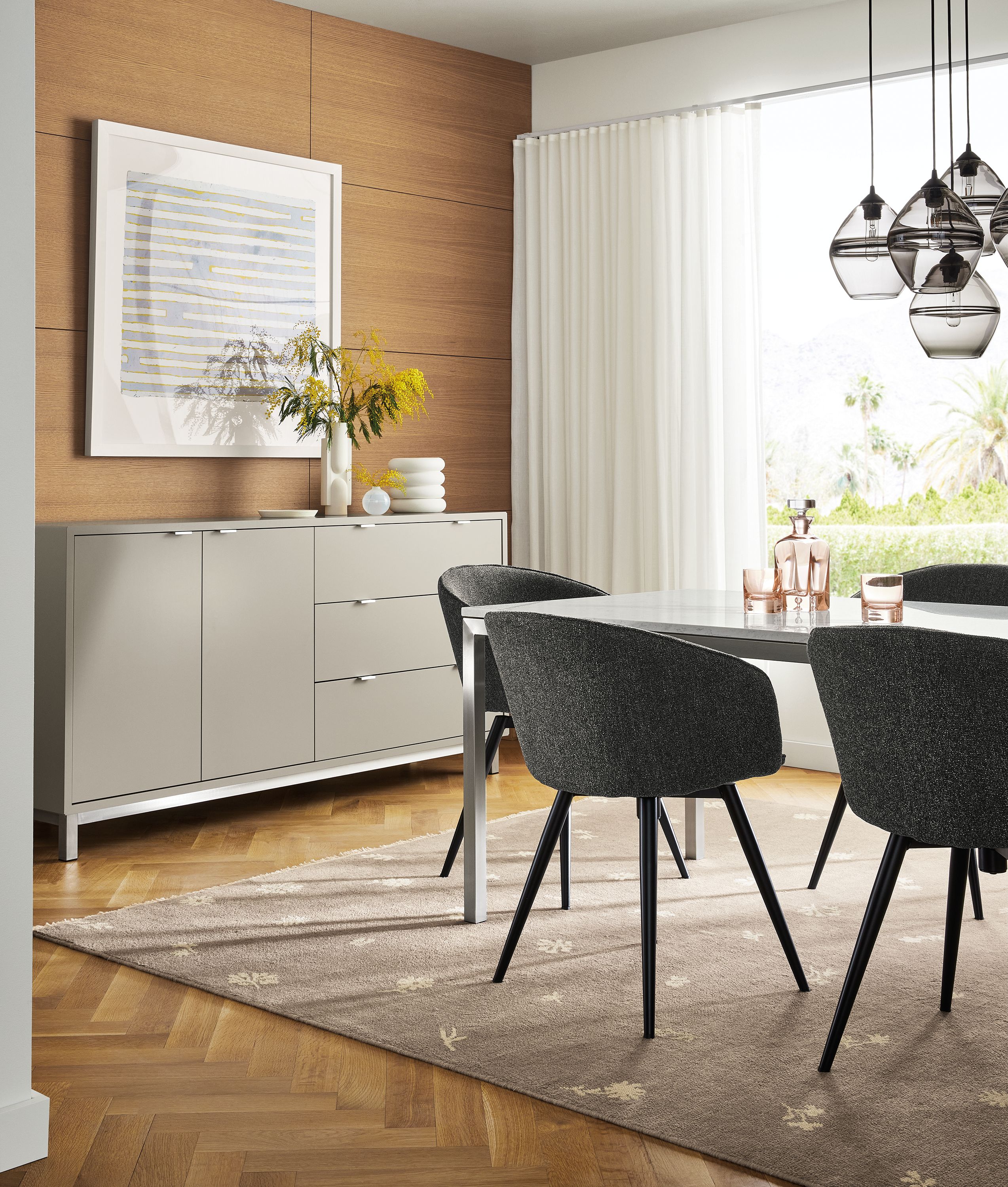 Dining area with Copenhagen 72-wide cabinet in taupe with Marbled white quartz top, Parsons table and Sylvan swivel chairs and Tansy rug.