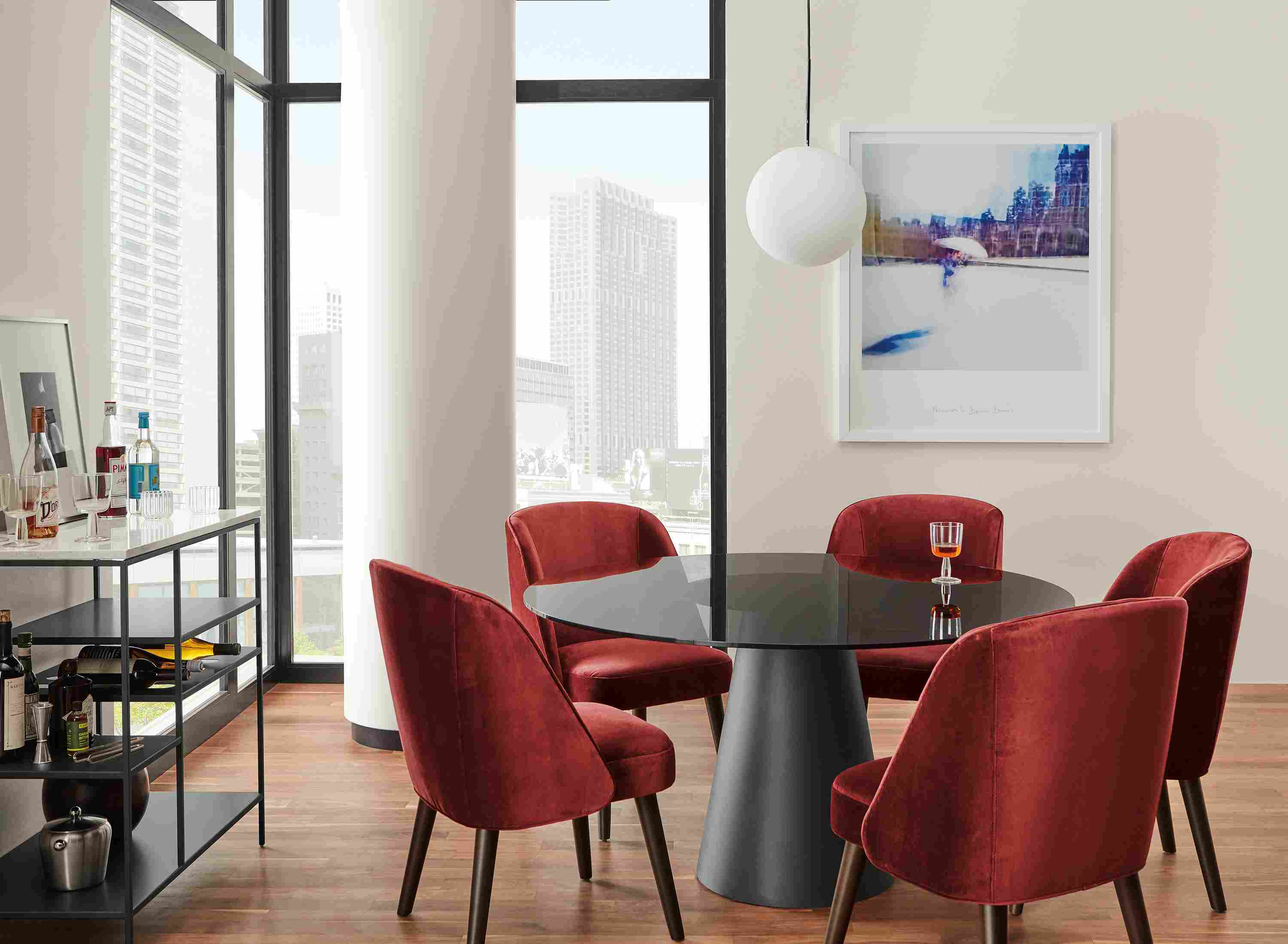 Dining area with Cora chairs in Vance Paprika, Decker table in Graphite with Smoked glass top and  Bowen Counter Table with Wine Shelf.