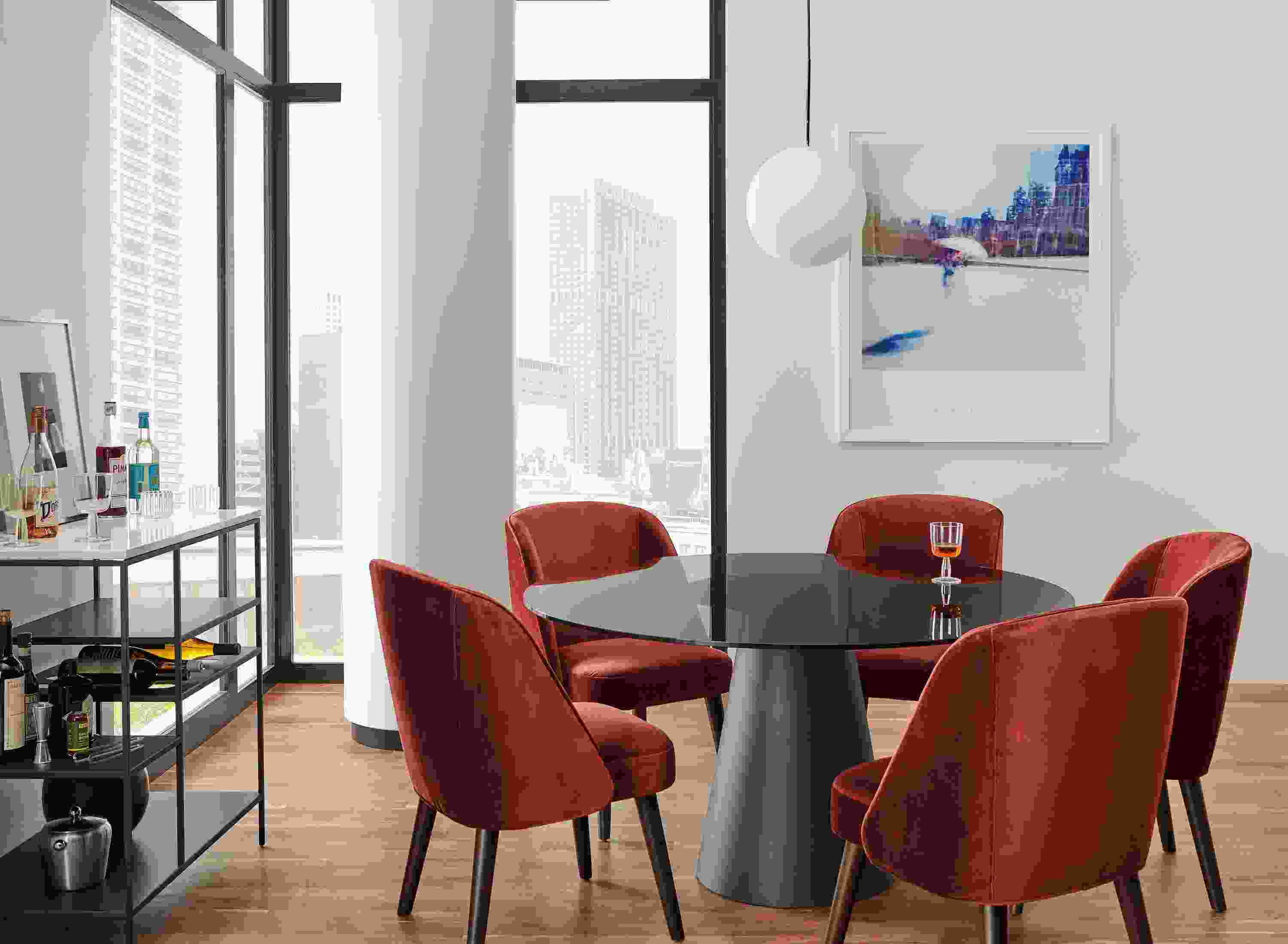 Dining area with Cora chairs in Vance Paprika, Decker table in Graphite with Smoked glass top and  Bowen Counter Table with Wine Shelf.