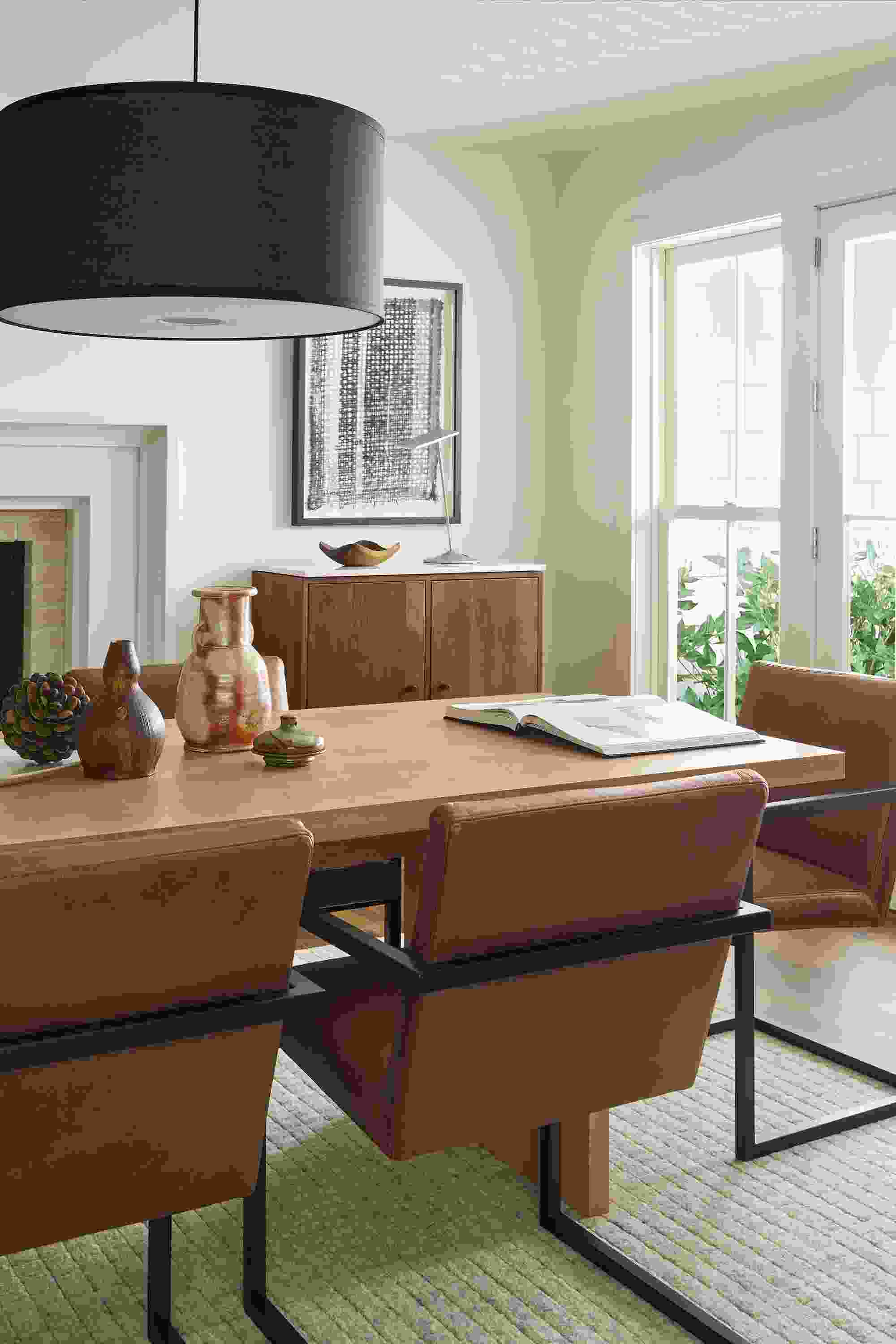 Dining room detail shot of Corbett table in rye on red oak and Lira arm chairs in Laino Cognac leather.
