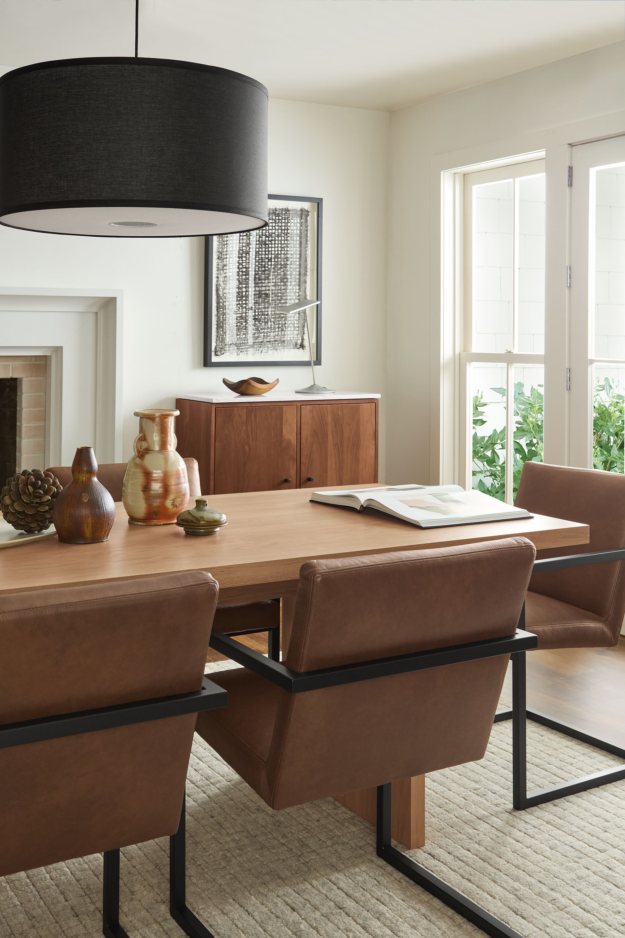 Dining room detail shot of Corbett table in rye on red oak and Lira arm chairs in Laino Cognac leather.