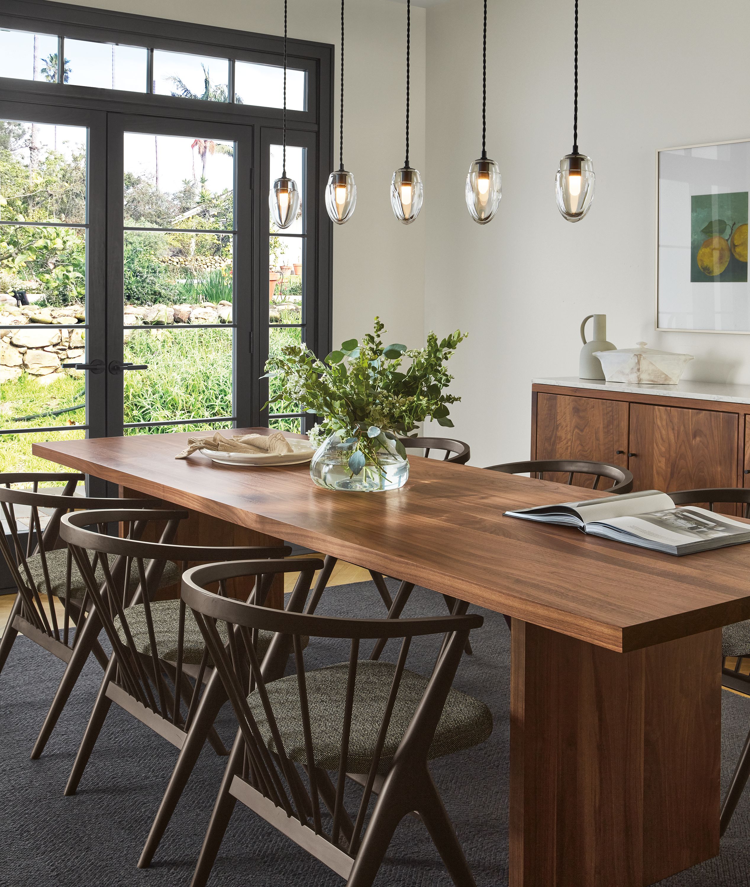 Dining room with Corbett dining table in walnut, Soren chairs, Polar pendant set of five.