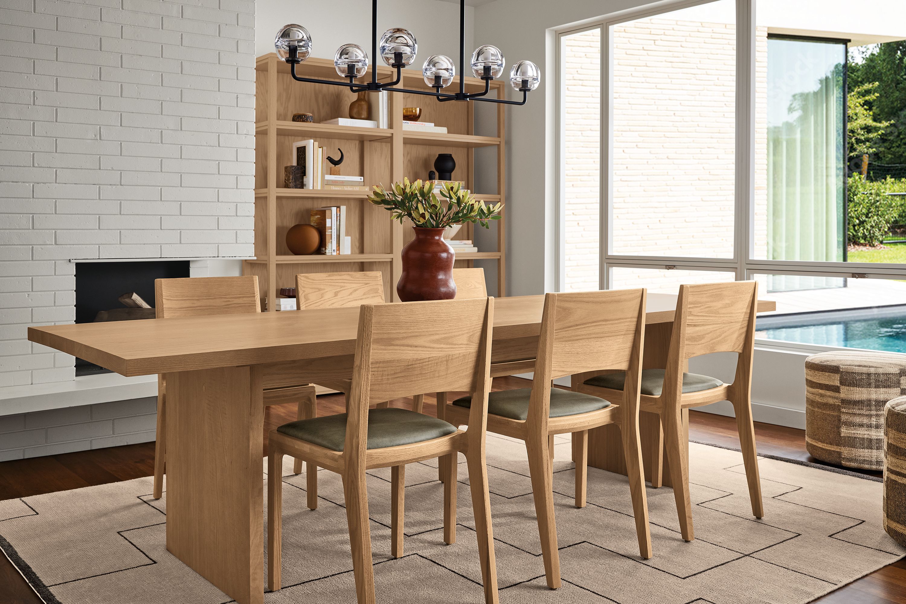 Dining room with Corbett 104-wide table and 6 Haven chairs all in rye on red oak and Navi 8 by 10 rug in Ivory/Black.
