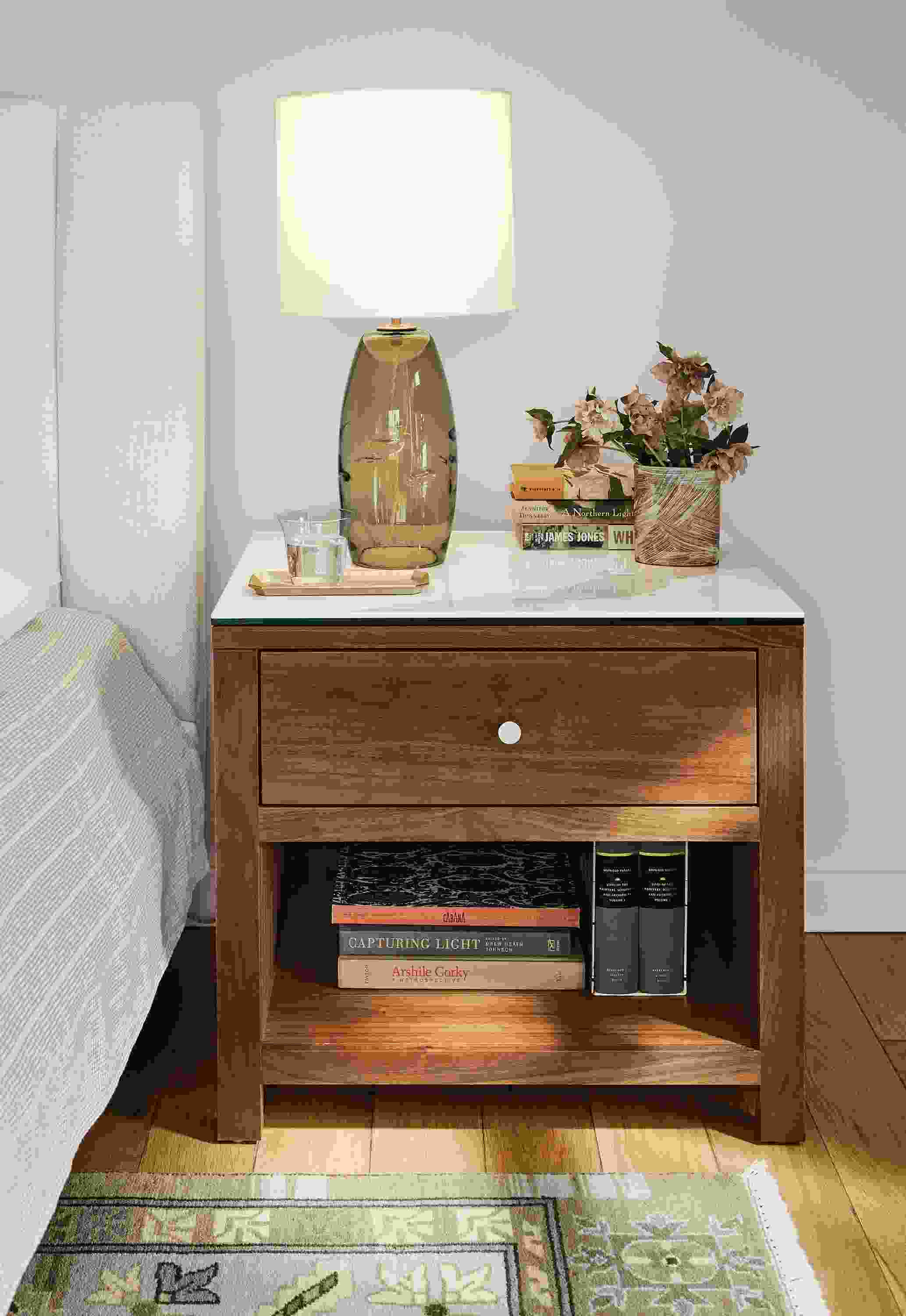 Bedroom with closeup of Corwin 26-wide nightstand in walnut with Marbled white ceramic top and Grace table lamp in olive.