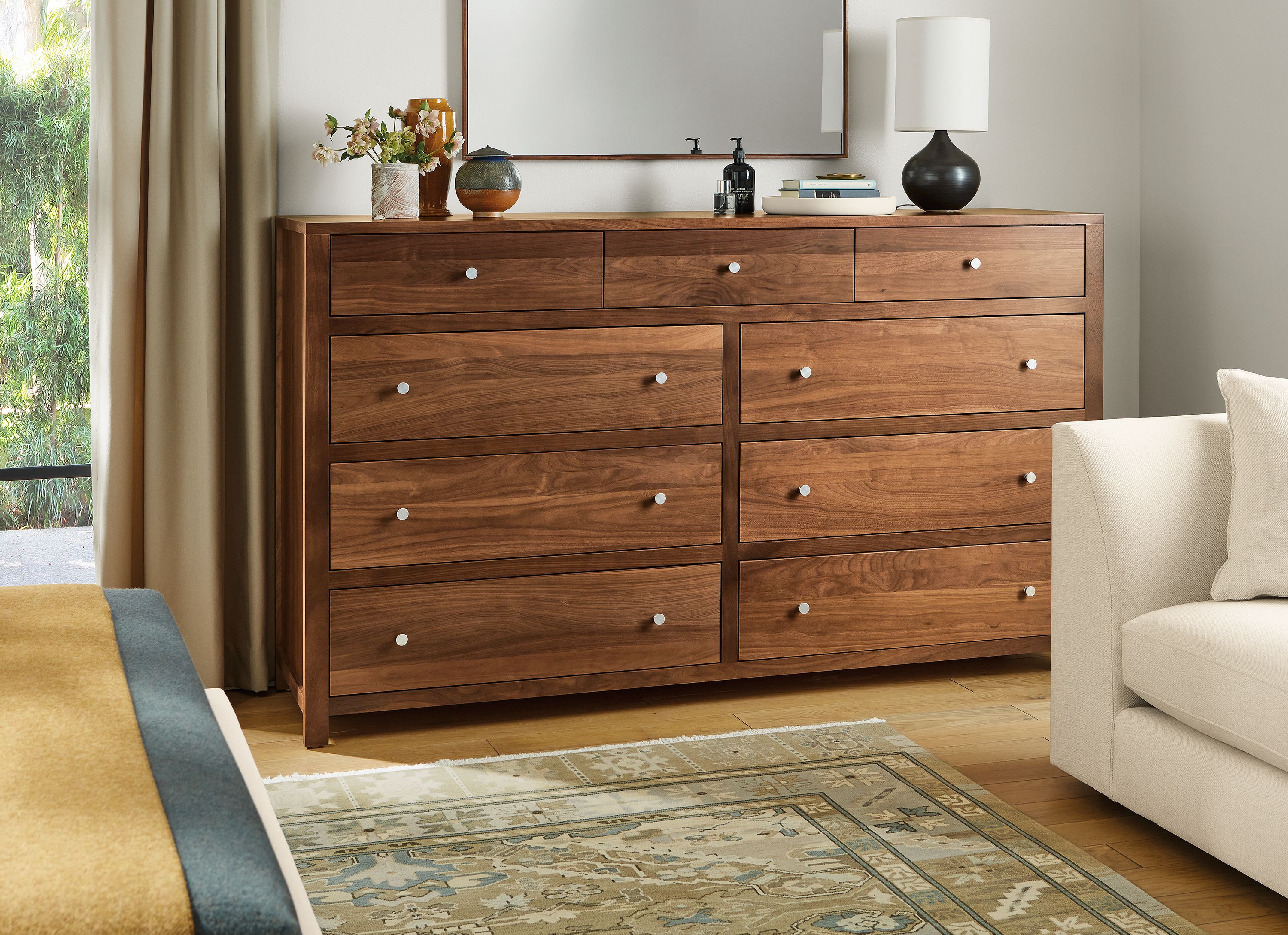 Bedroom area with Corwin 76-wide nine-drawer dresser in walnut, Astaire sofa in Sumner ivory and Kayseri rug in moss.