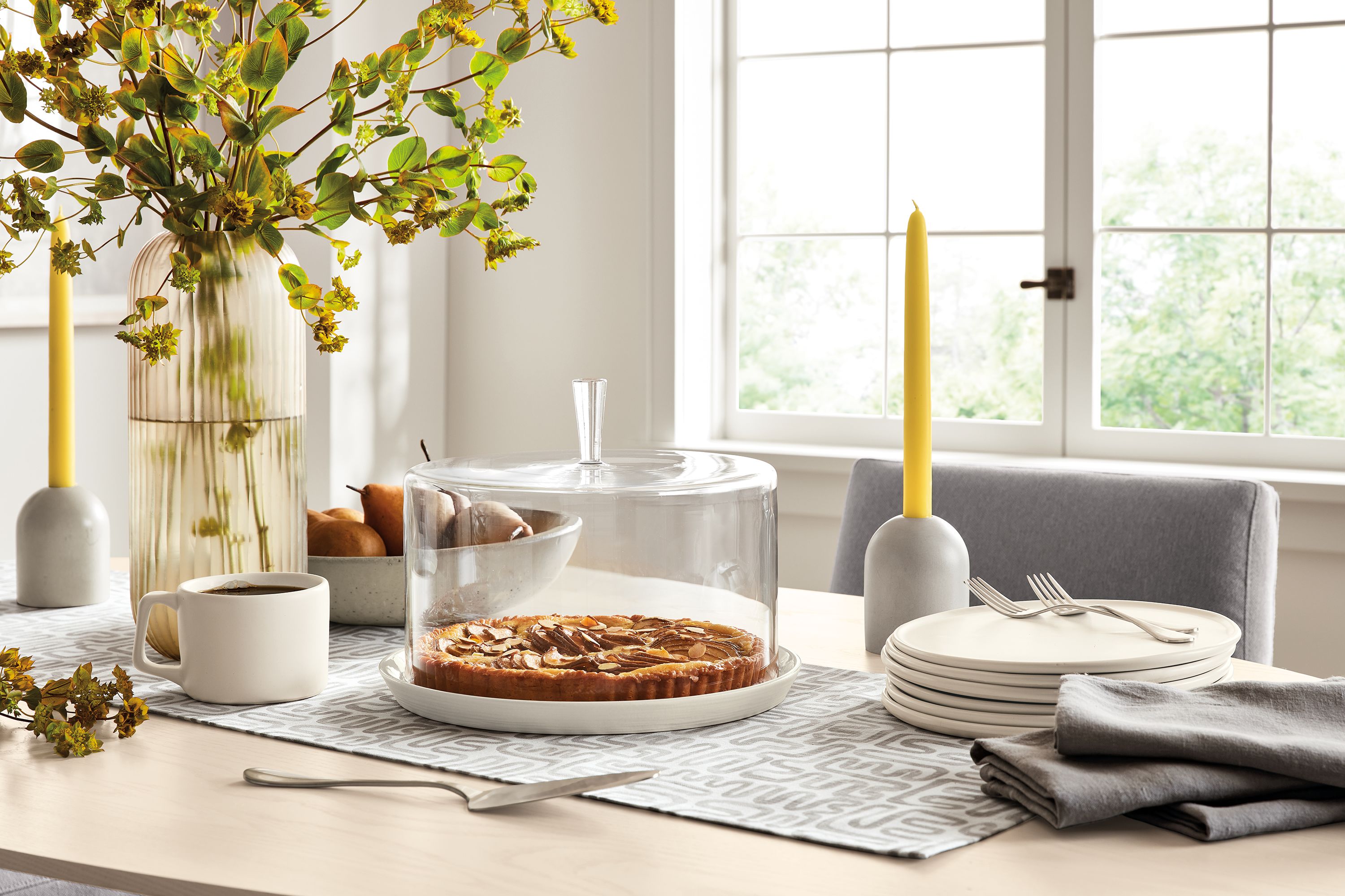 detail of dining table with coupole cake dome, nadia plates, emile candle holder, livia table runner.