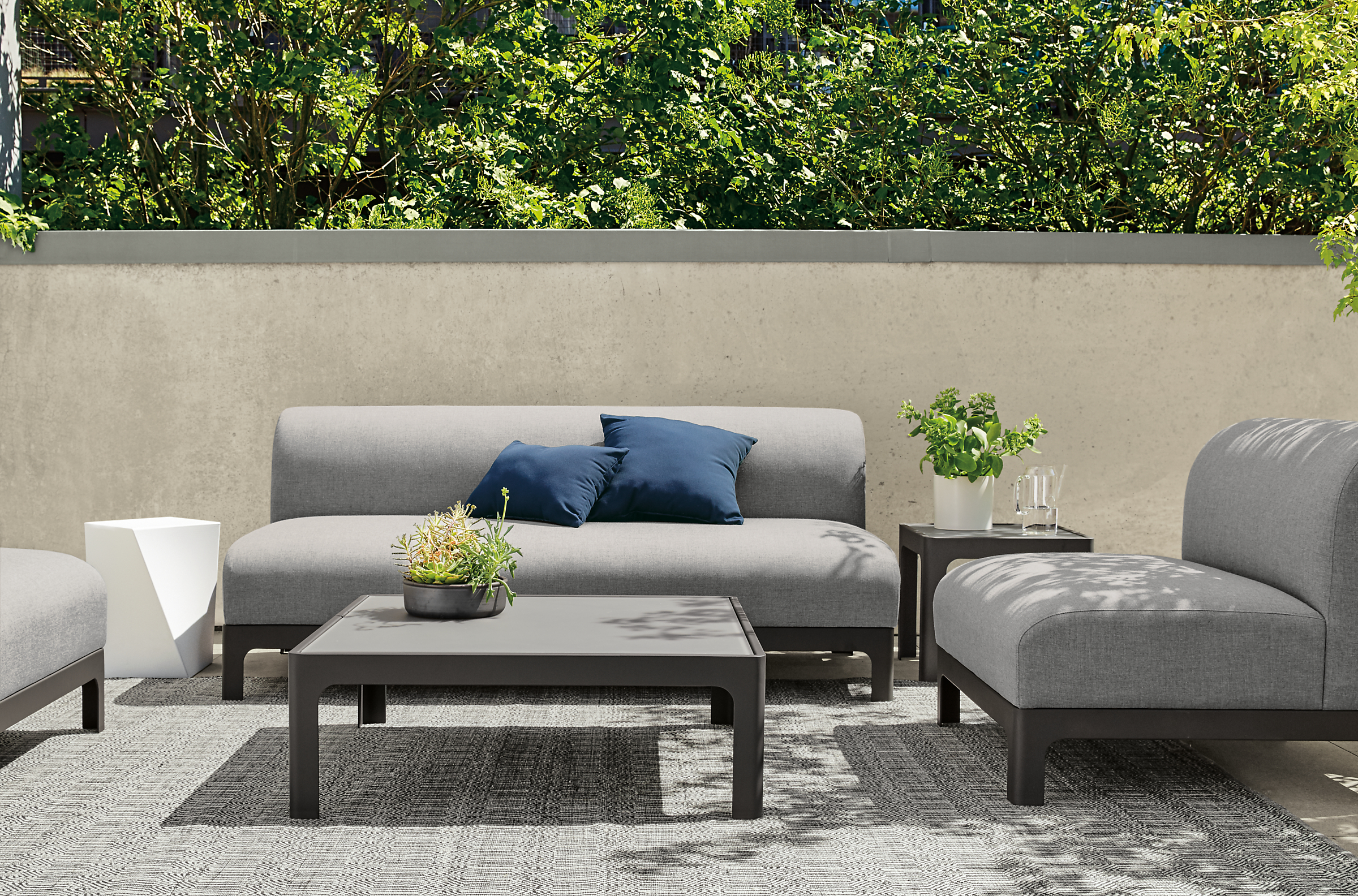 Outdoor Crescent sofa and chair on rug.