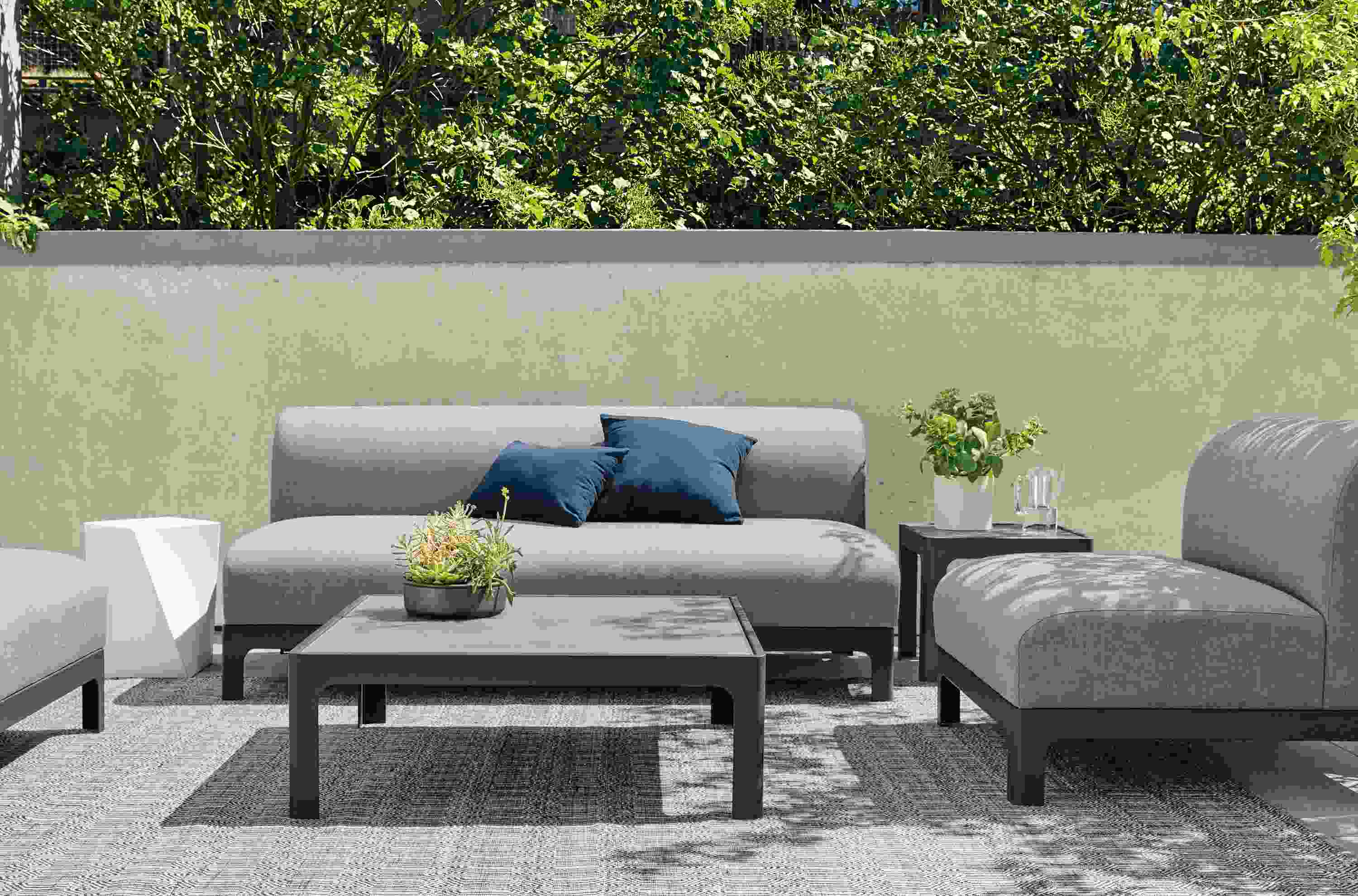 Outdoor Crescent sofa and chair on rug.