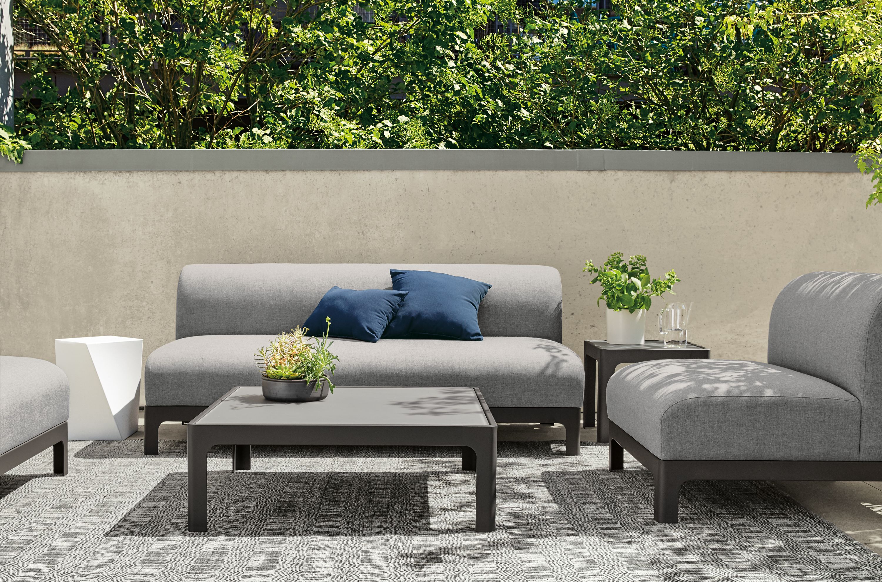 Outdoor Crescent sofa and chair on rug.