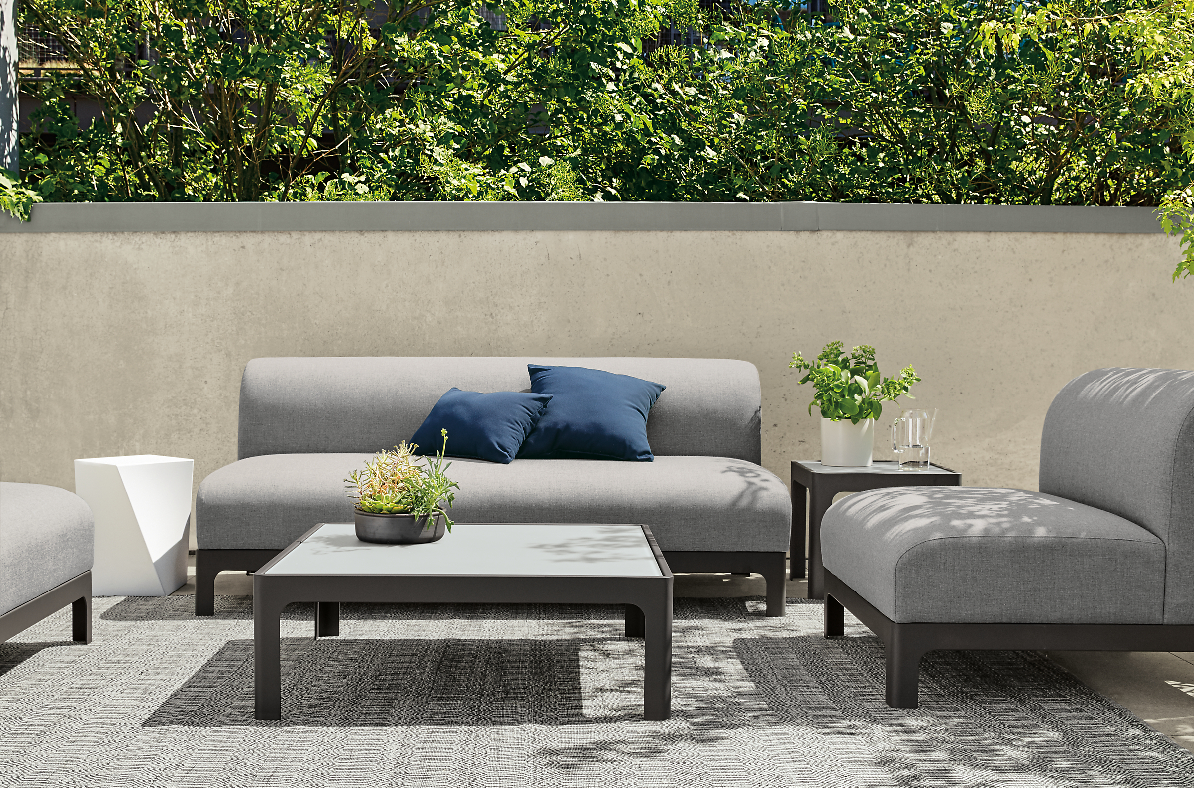 Modern Crescent outdoor sofas in grey fabric and table.