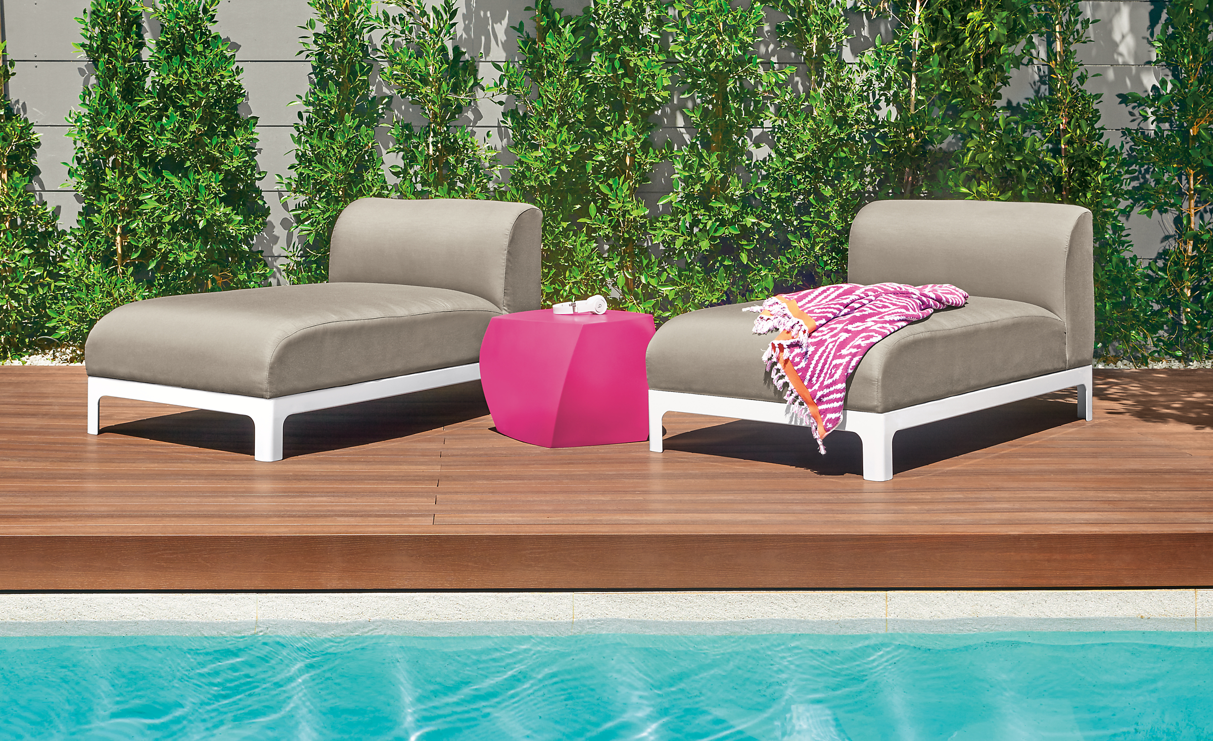 Detail of two Crescent outdoor chaises by pool.