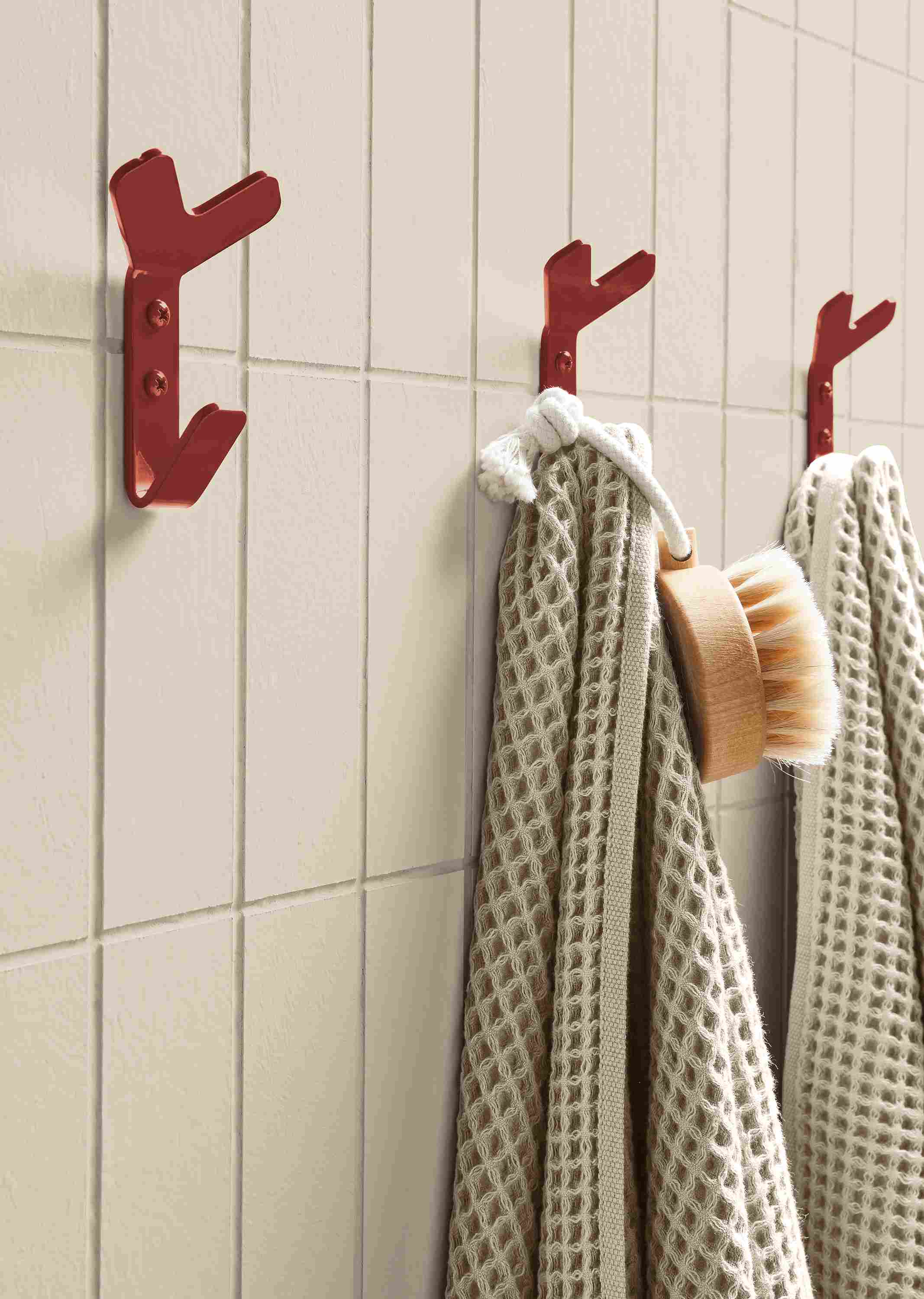 Bathroom wall with crew mini triple wall hooks in brick powdercoat.