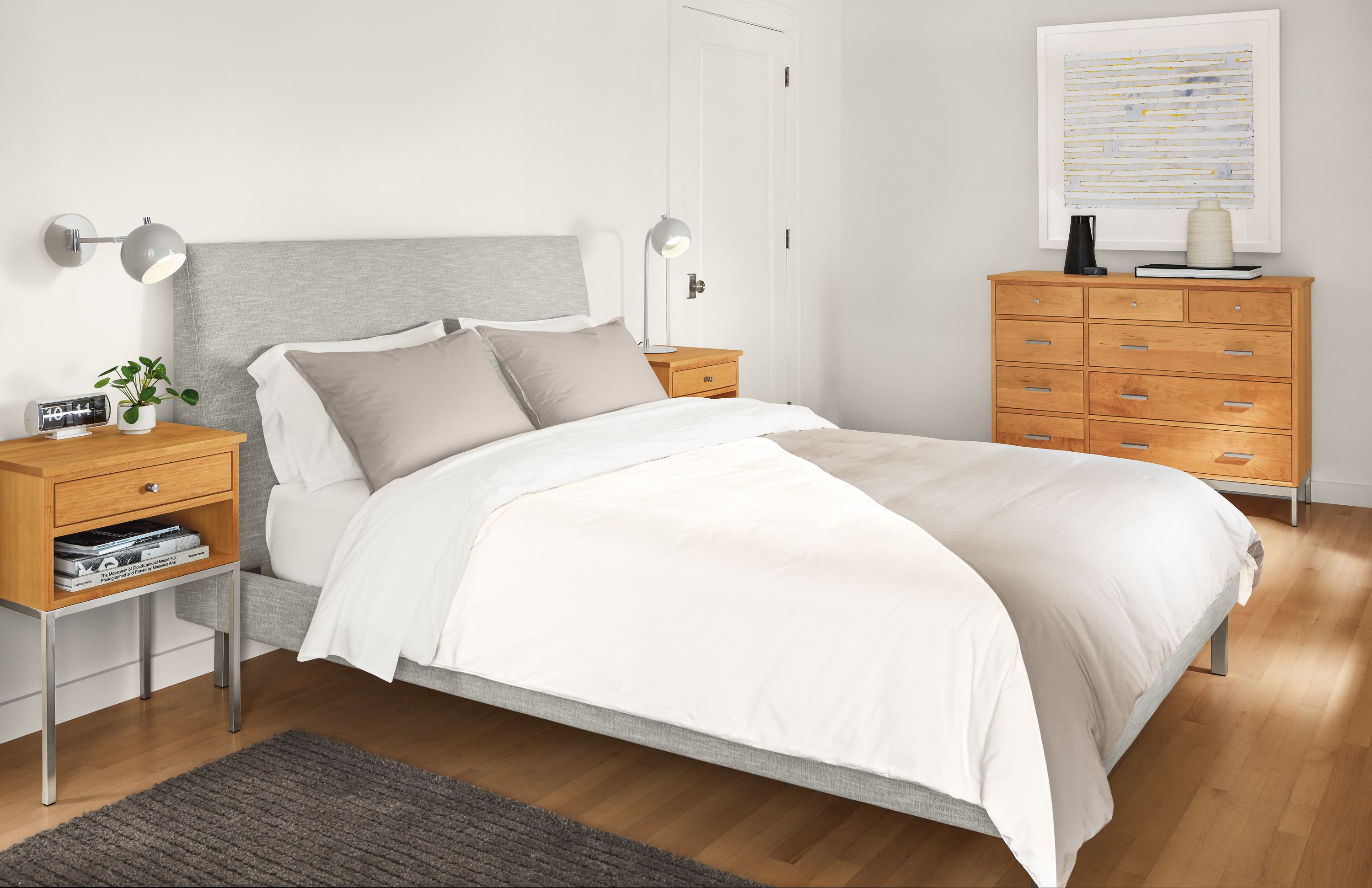 Detail of Crossway duvet cover in natural-grey with Camber wall sconce and table lamp in grey, and Linear nightstands in cherry.