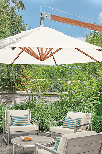 cumulo patio umbrella above montego lounge chairs and montego coffee table in aged ash.