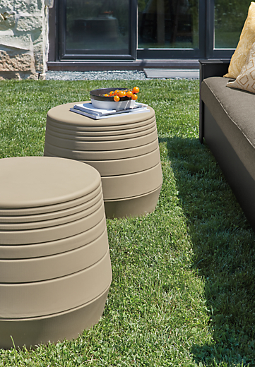 Two Cusp 21-round stools in umber in outdoor setting.