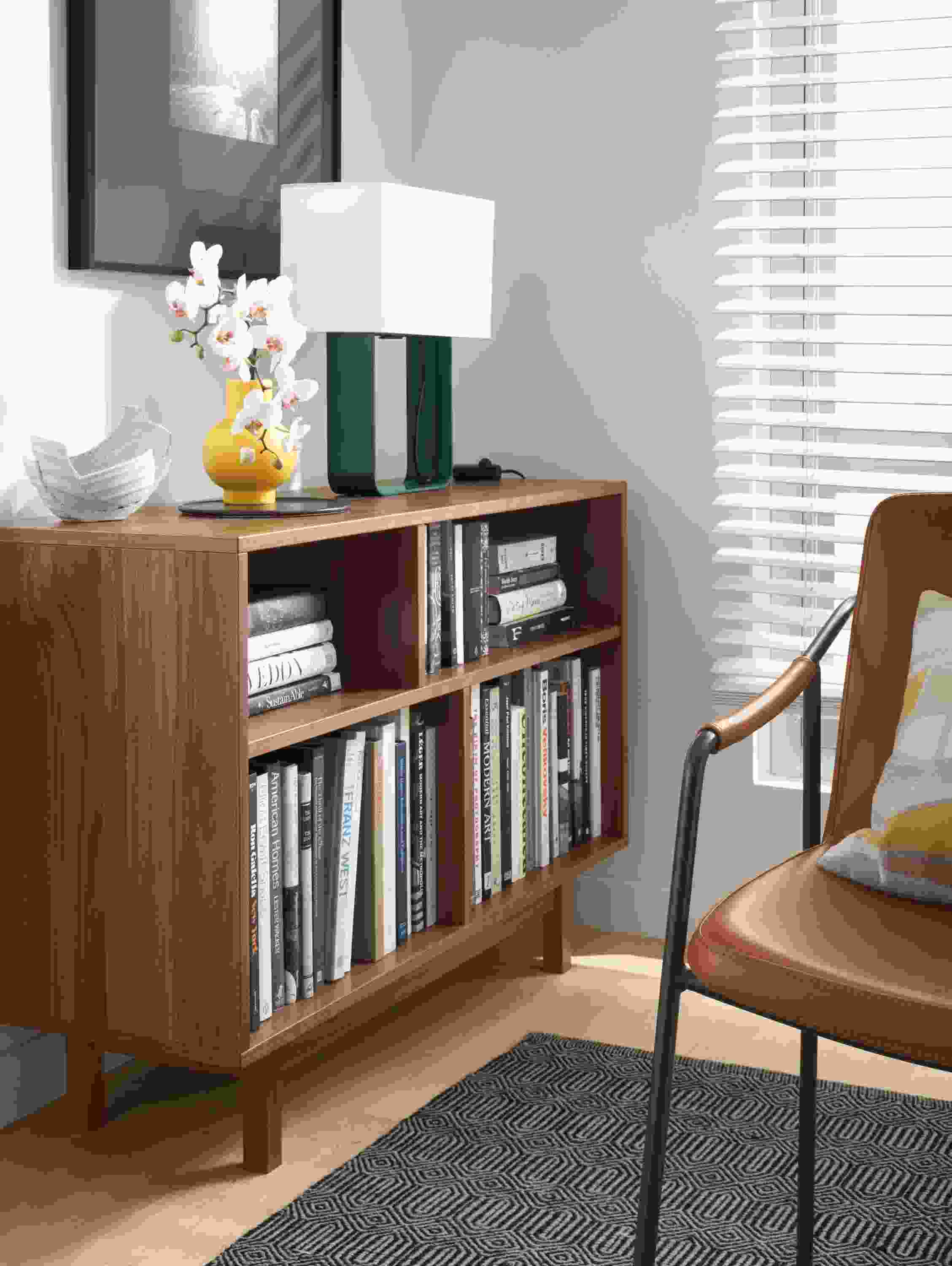 Dahl console bookcase in walnut near a living room window.