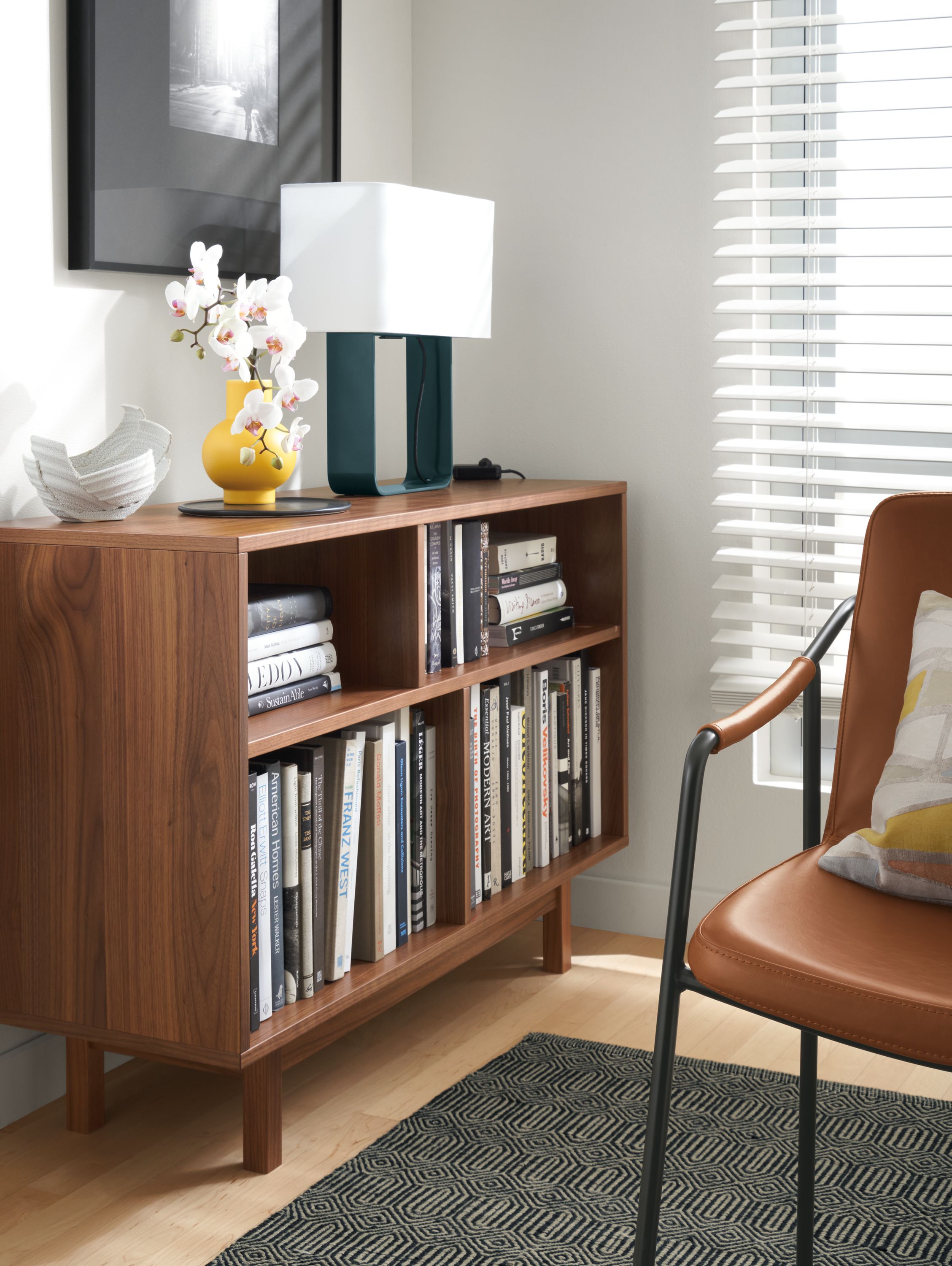 Dahl console bookcase in walnut near a living room window.