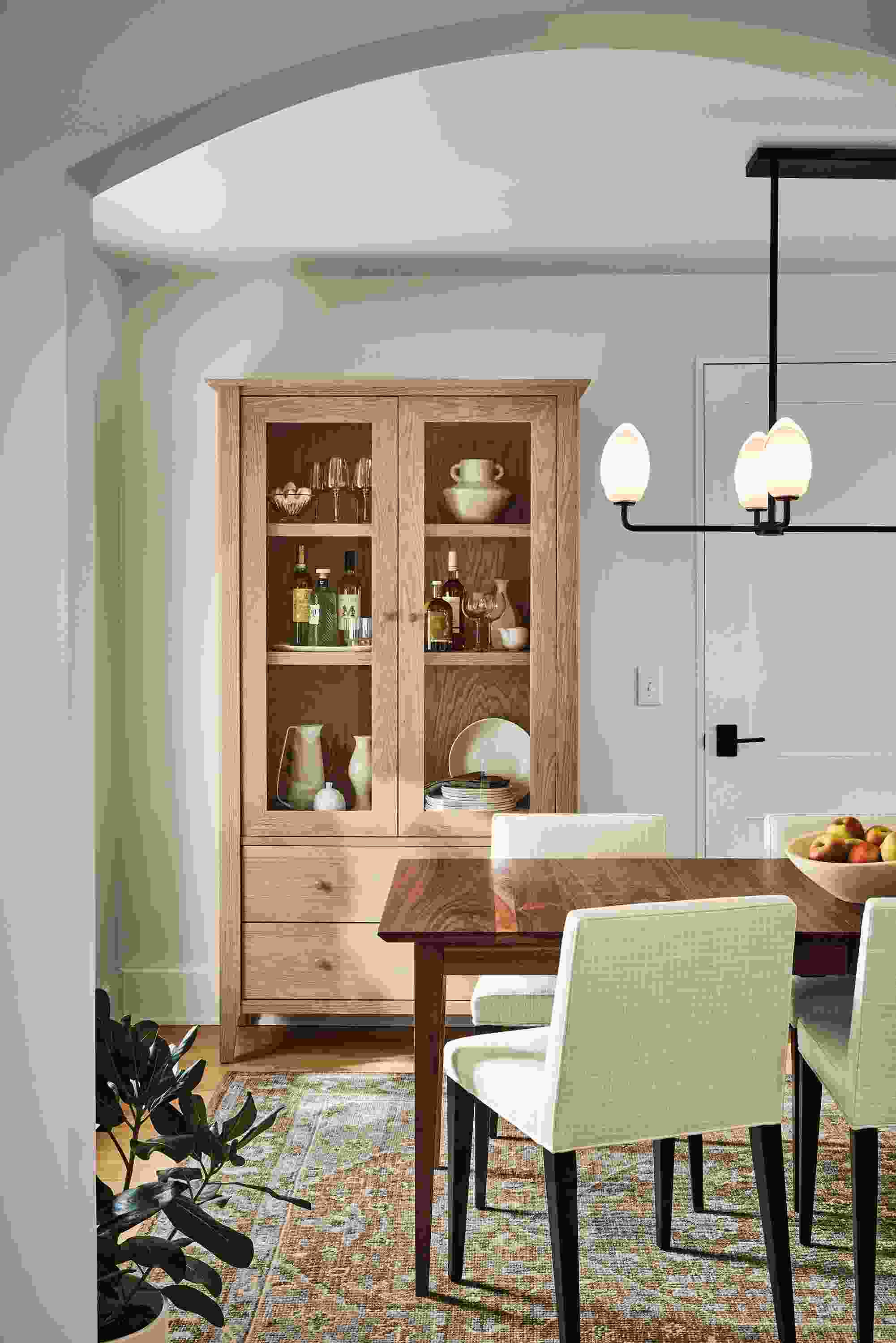 Dining room with danbury storage cabined in rye on red oak, adams extension table in walnut and veda 8 by 10 rug in moss.