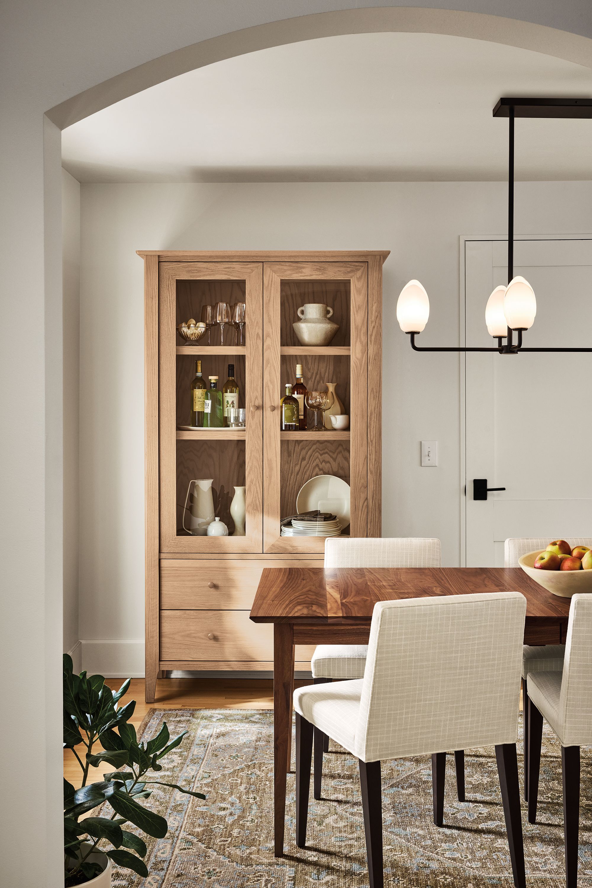 Dining room with danbury storage cabined in rye on red oak, adams extension table in walnut and veda 8 by 10 rug in moss.