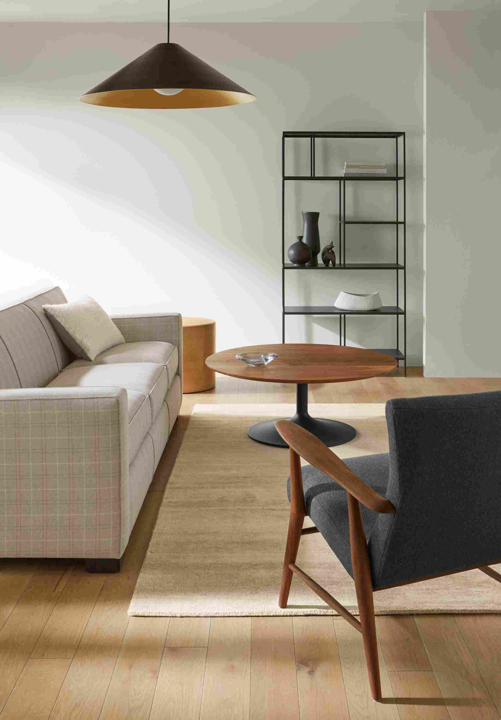 Living room with Dean Sofa in Kivett Putty, Aria round coffee table in graphite and walnut and Impression rug in taupe.