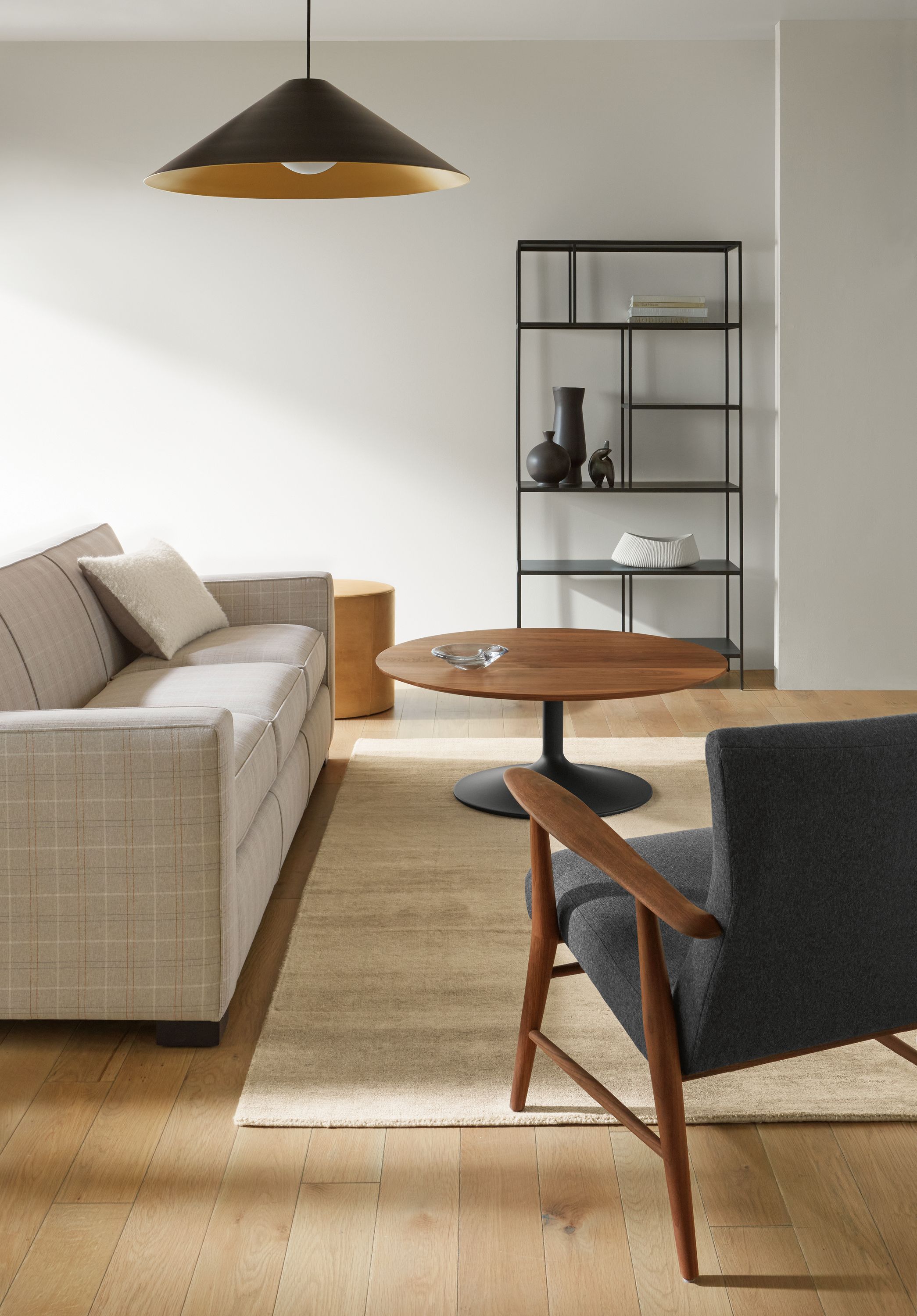 Living room with Dean Sofa in Kivett Putty, Aria round coffee table in graphite and walnut and Impression rug in taupe.