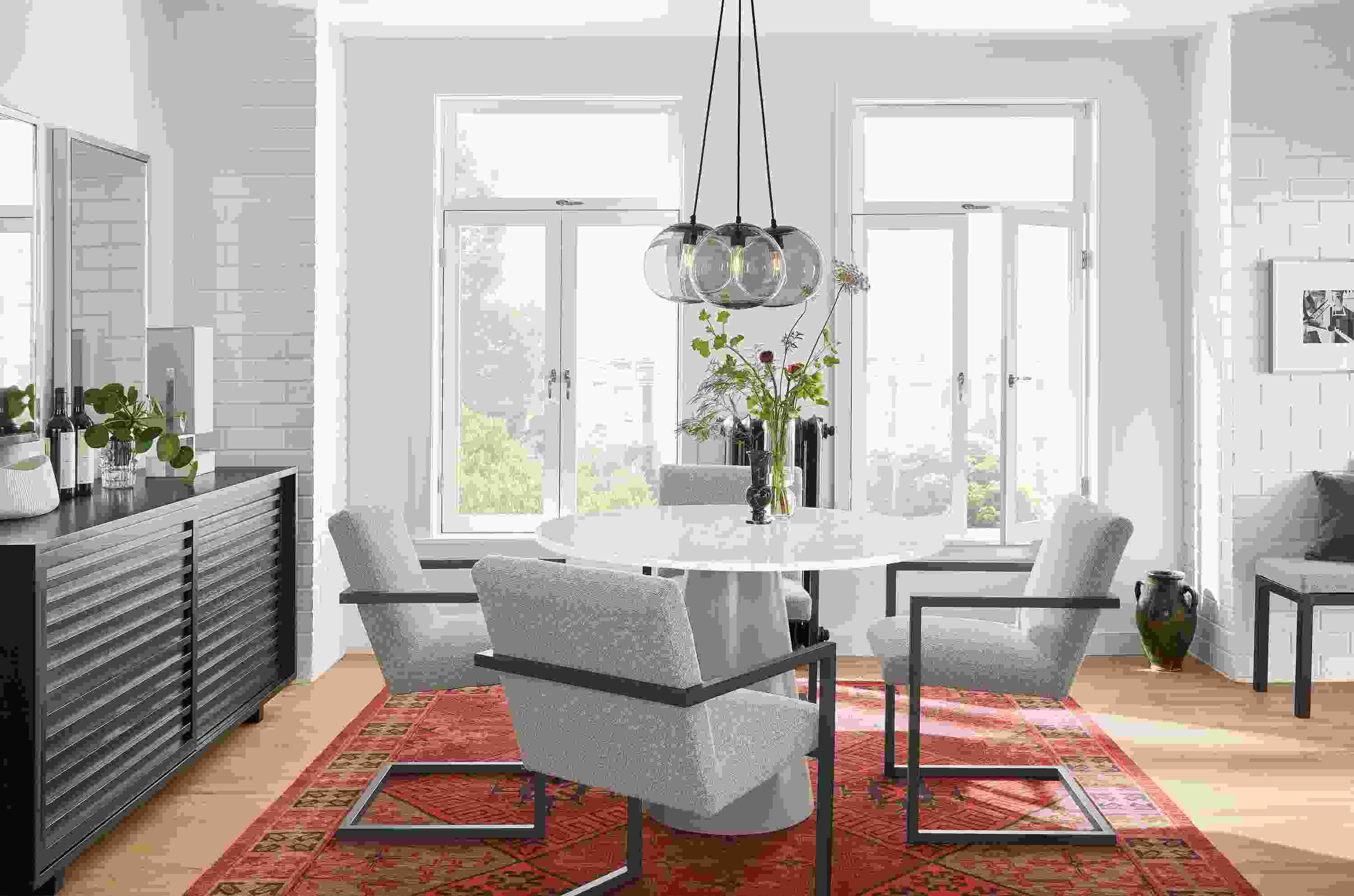 Detail of Decker round table with marbled white quartz top and taupe base in small dining room.