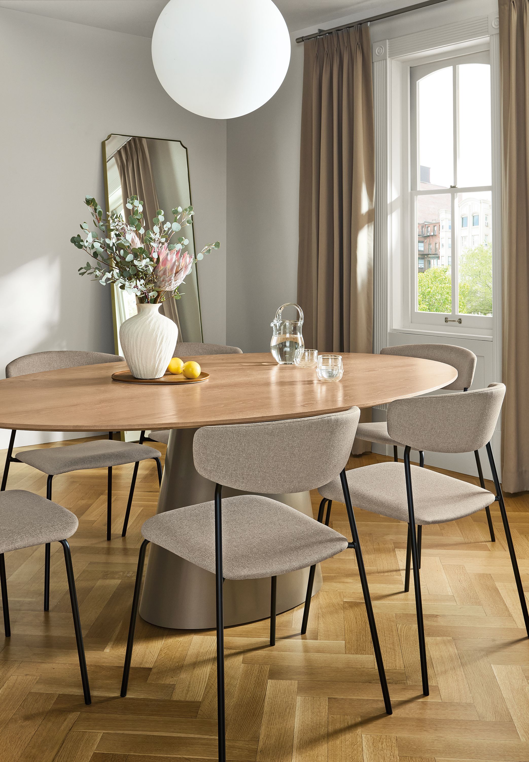 Dining room with Decker oval table in mineral with rye on red oak top and 6 wolfgang side chairs in medley oatmeal.