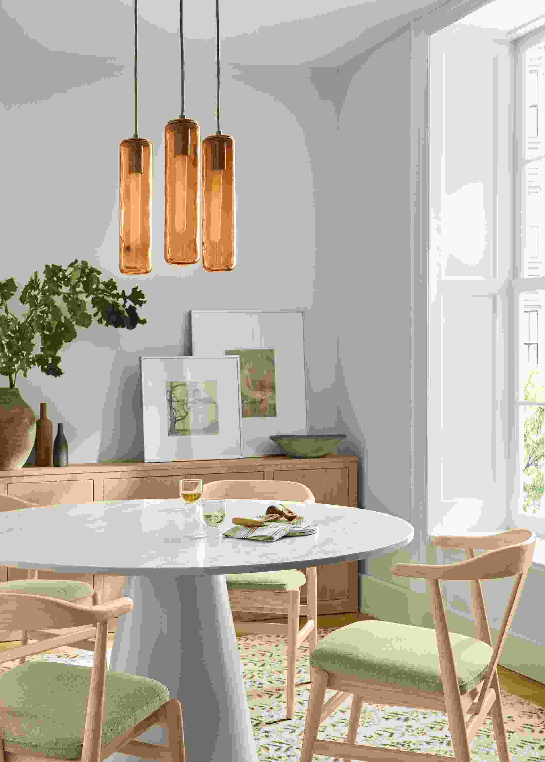 Dining room with Decker round table in marbled warm white quartz and taupe and 4 Evan arm chairs in Myers Taupe.