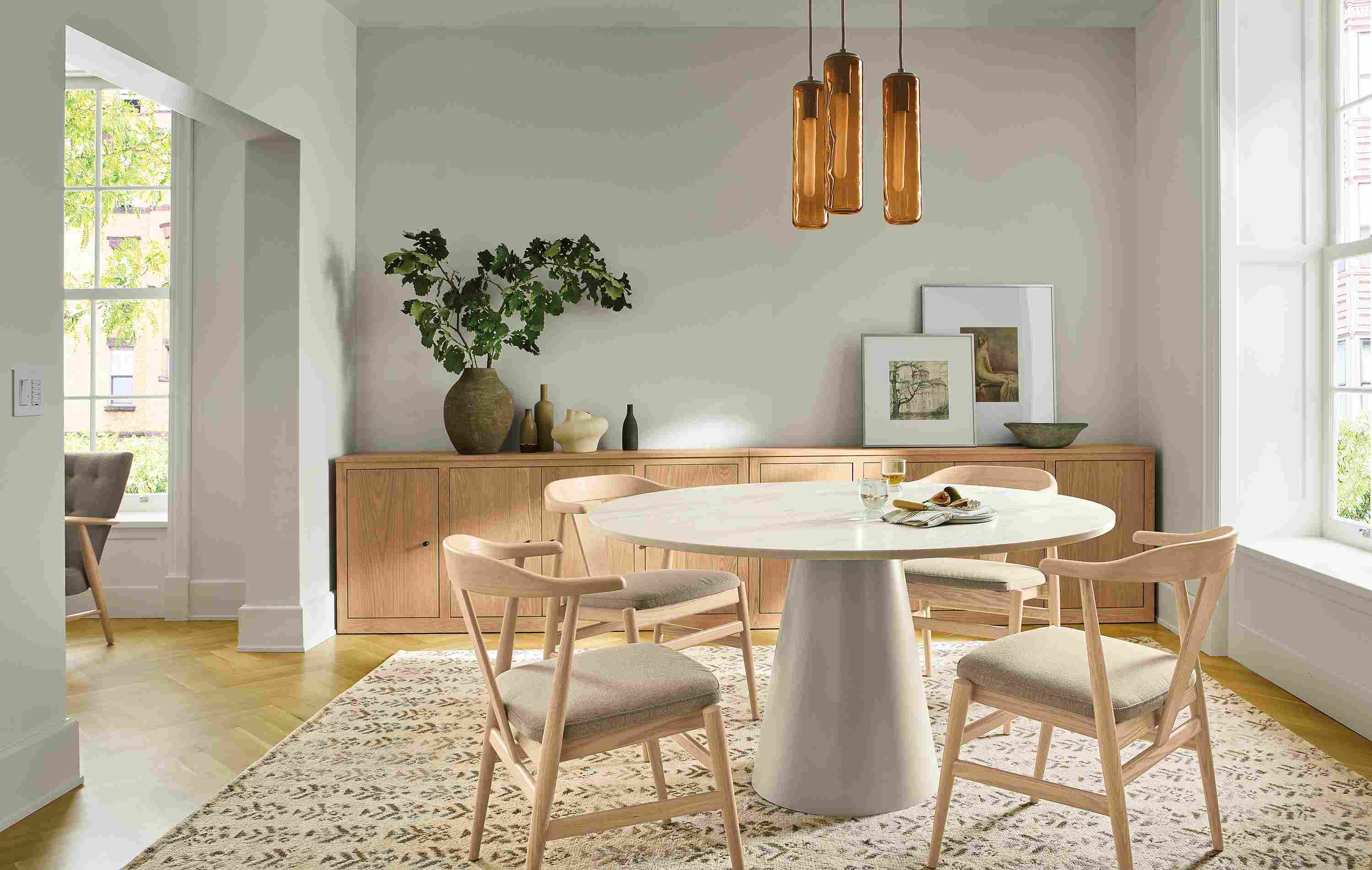 Dining room with Decker 54-diameter table in taupe with marbled warm white quartz top and Evans arm chairs.