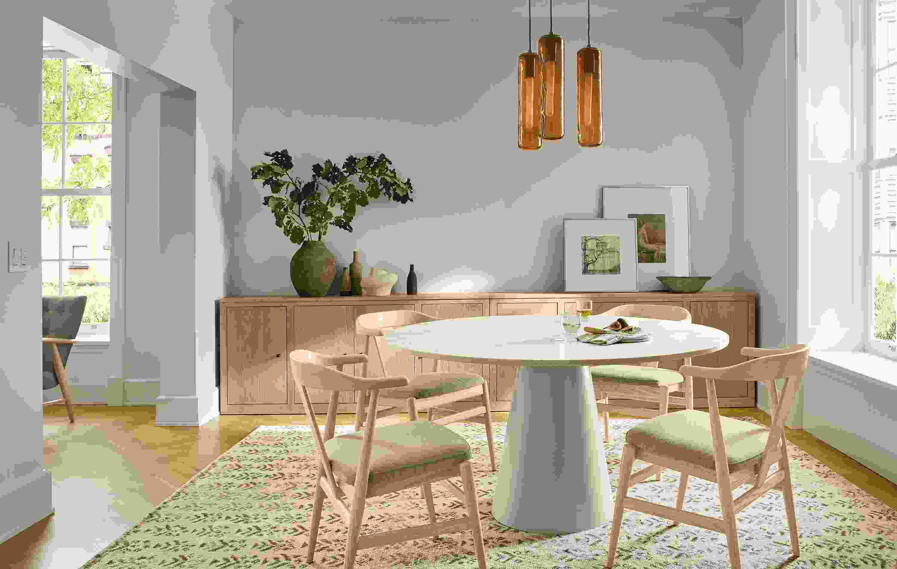 Dining room with Decker 54-diameter table in taupe with marbled warm white quartz top and Evans arm chairs.