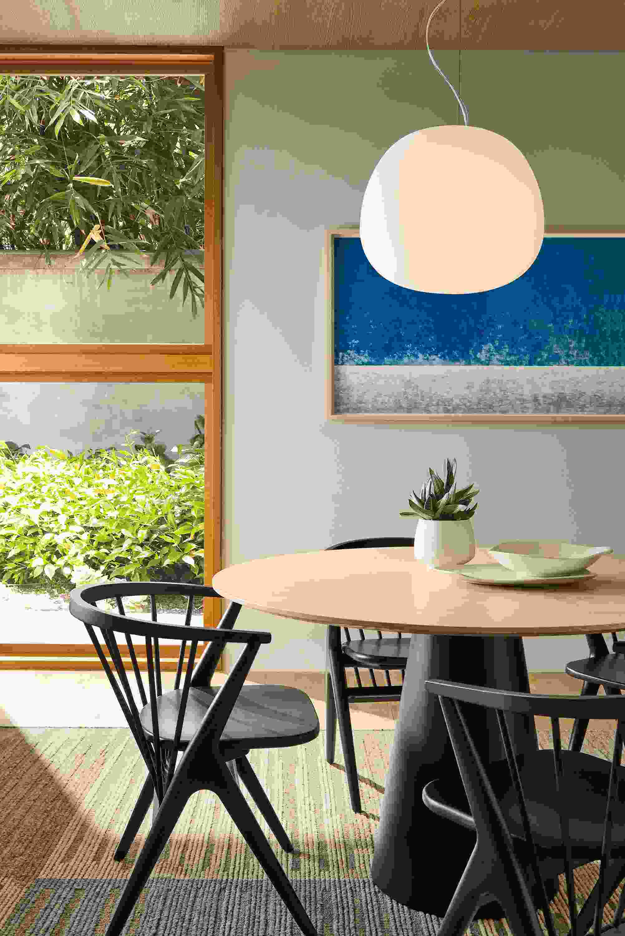Dining room with decker 48-diameter round table in graphite with salt on red oak and soren chairs in charcoal on cherry.