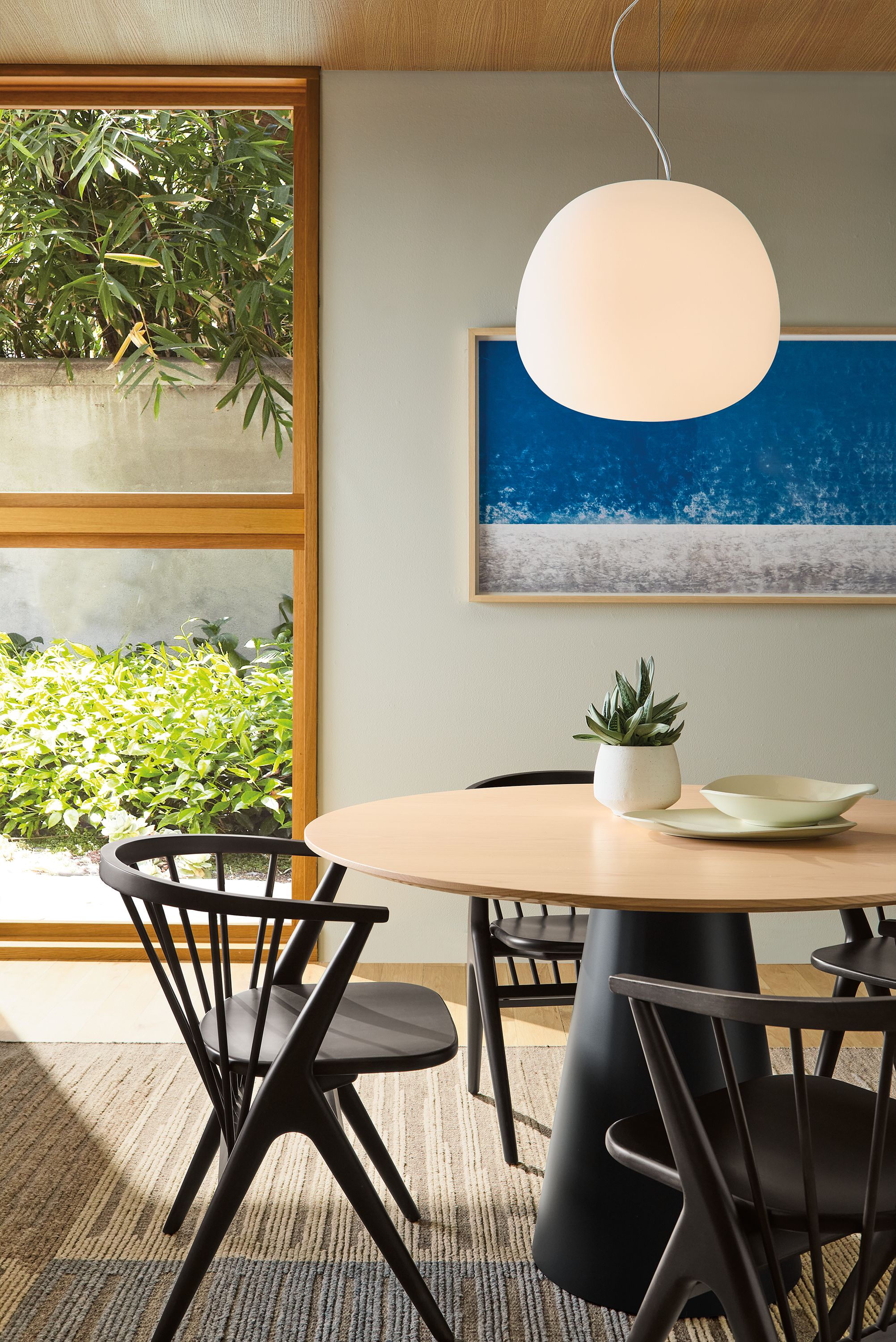 Dining room with decker 48-diameter round table in graphite with salt on red oak and soren chairs in charcoal on cherry.