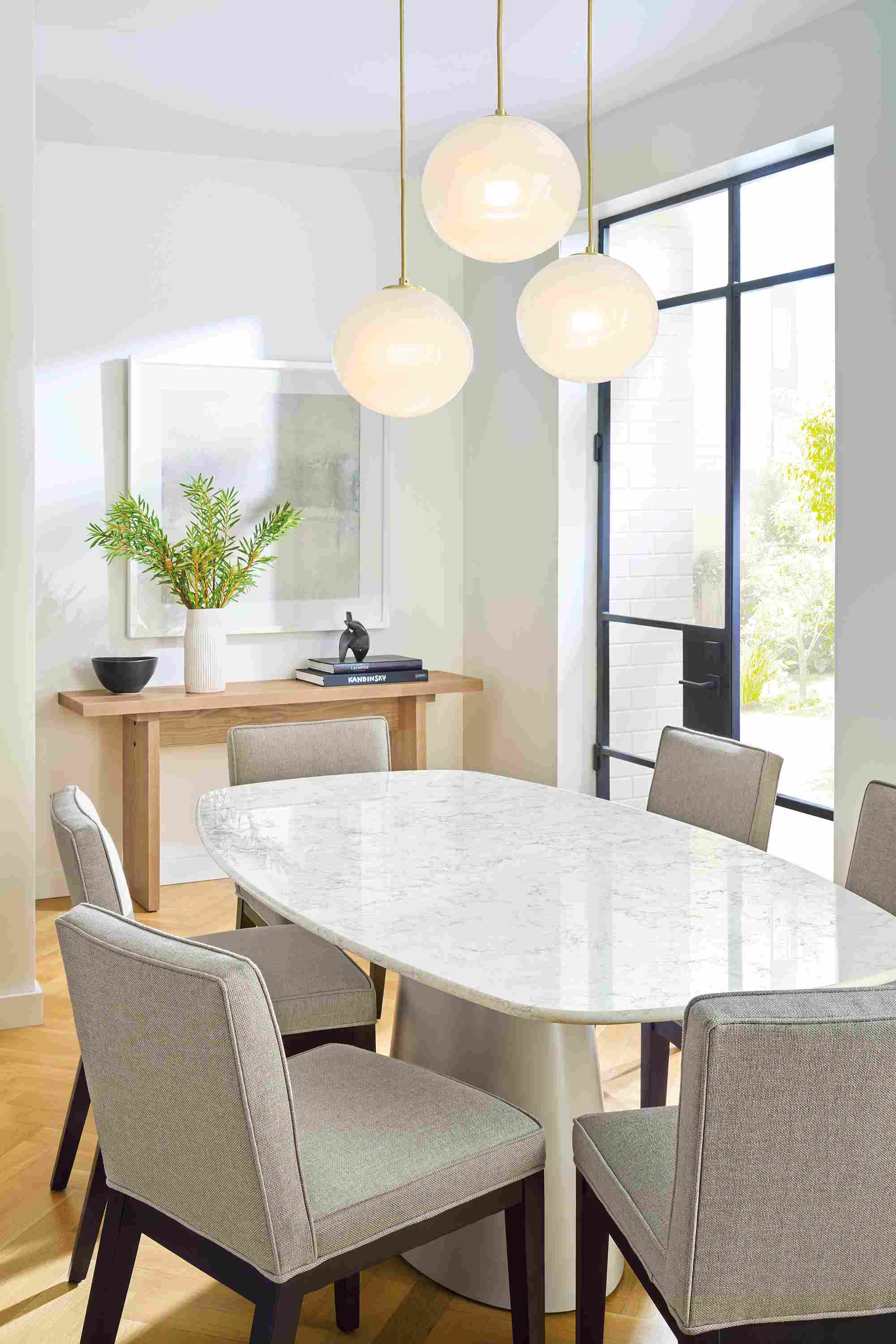 Dining room with Decker boat-top table in taupe and marbled white quartz and 6 Ansel chairs in sumner cement.
